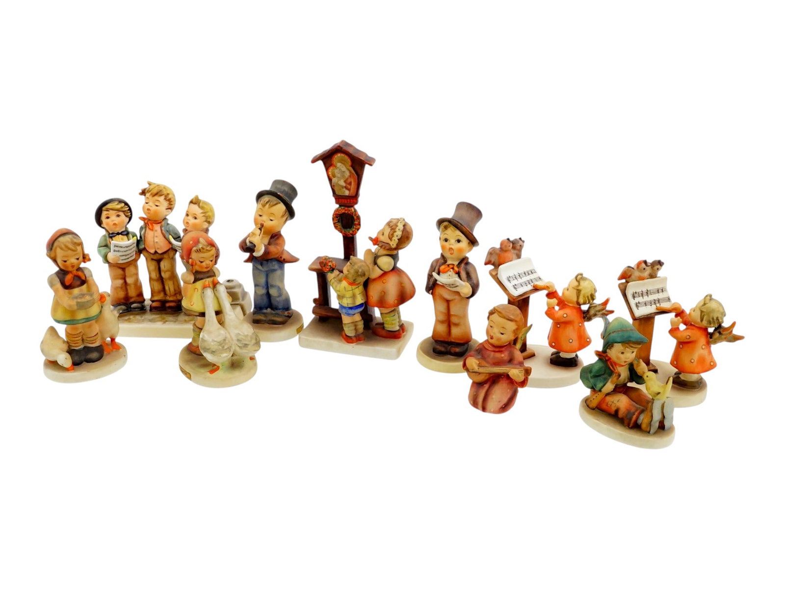 10 WEST GERMAN GOEBEL HUMMEL PORCELAIN FIGURINES: A collection of ten West German Goebel Hummel porcelain figurines representing children in costumes, with musical instruments, in various rural scenes with animals, baskets, fishing, and others. Figur