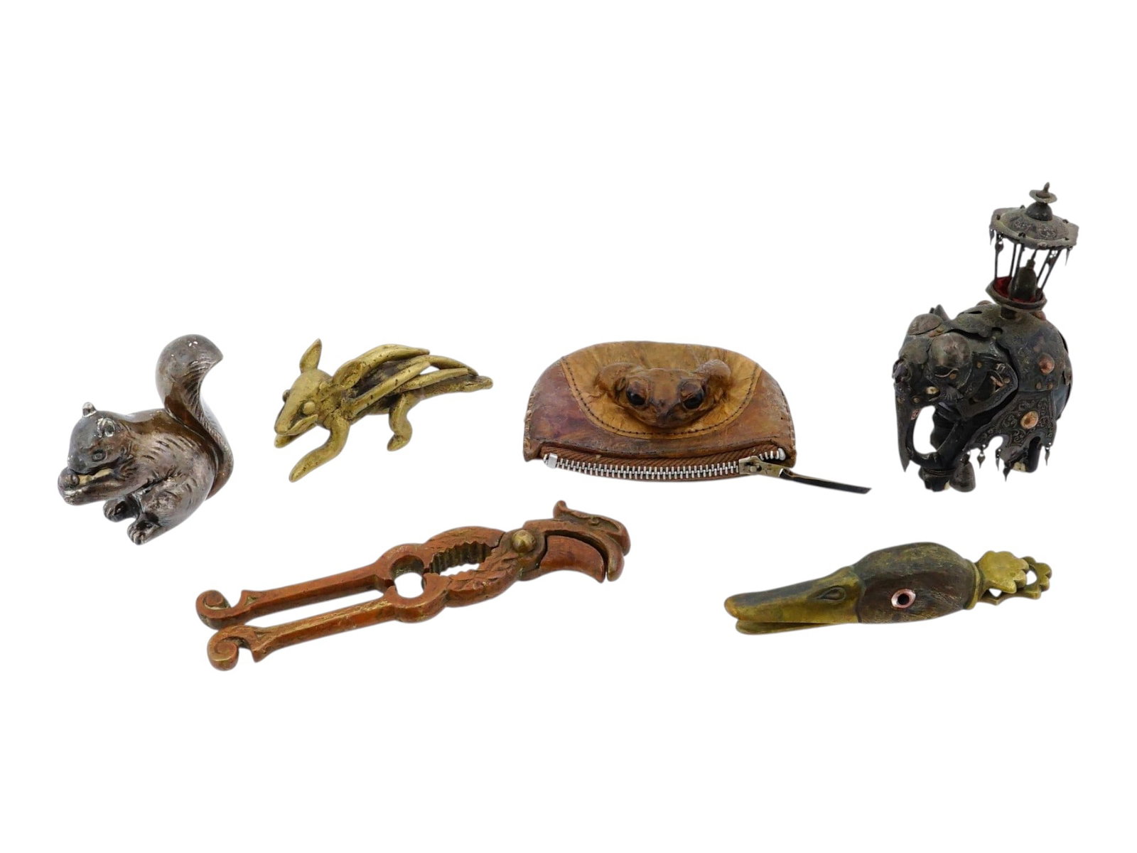 VARIOUS METAL ANIMAL SHAPED ITEMS AND ONE LEATHER PURSE: A collection of six items including a ceremonial ebony elephant, a toad coin purse made of natural material, a brass duck-head paper clip, a bird-shaped nutcracker, and miniature bronze squirrel and m