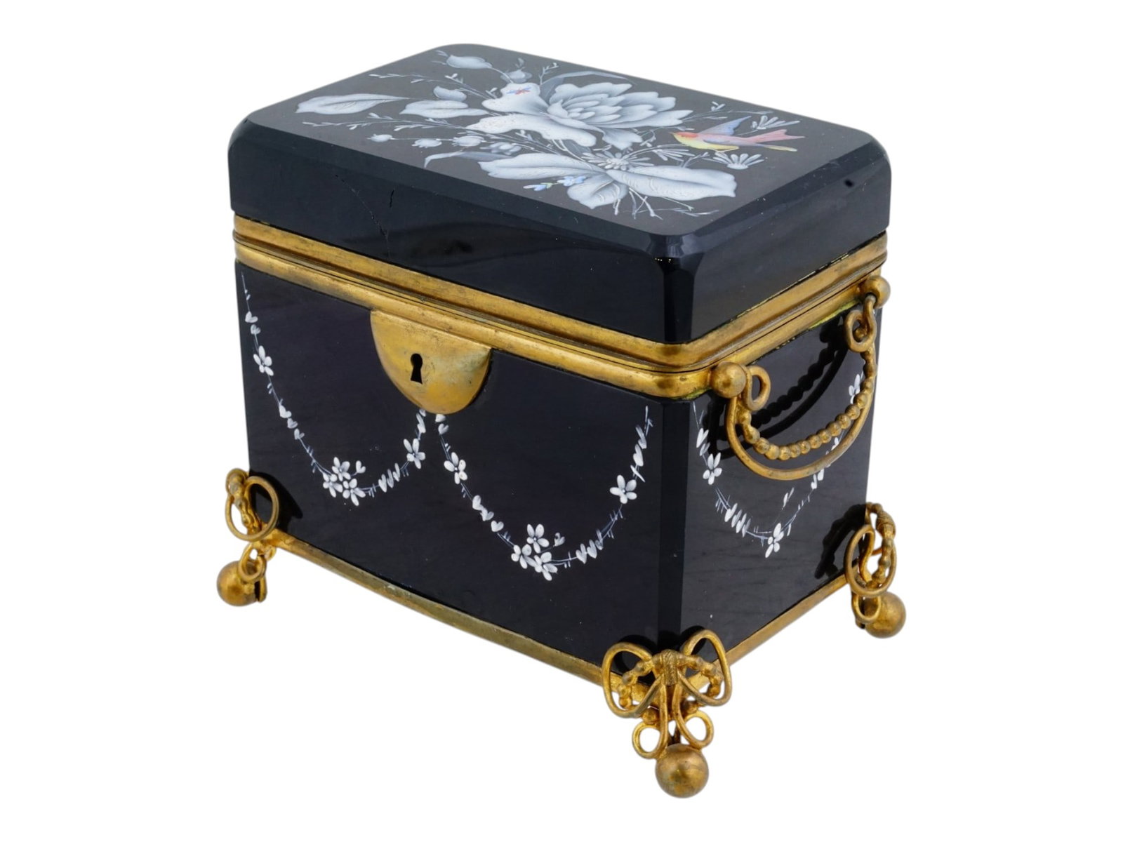 MARY GREGORY STYLE BLACK GLASS GILT BRASS CASKET BOX: A vintage Mary Gregory style black opaline glass gilt brass mounted casket box. The rectangular footed casket is decorated with white enamel garland motifs ornament on the sides. The hinged lid is emb
