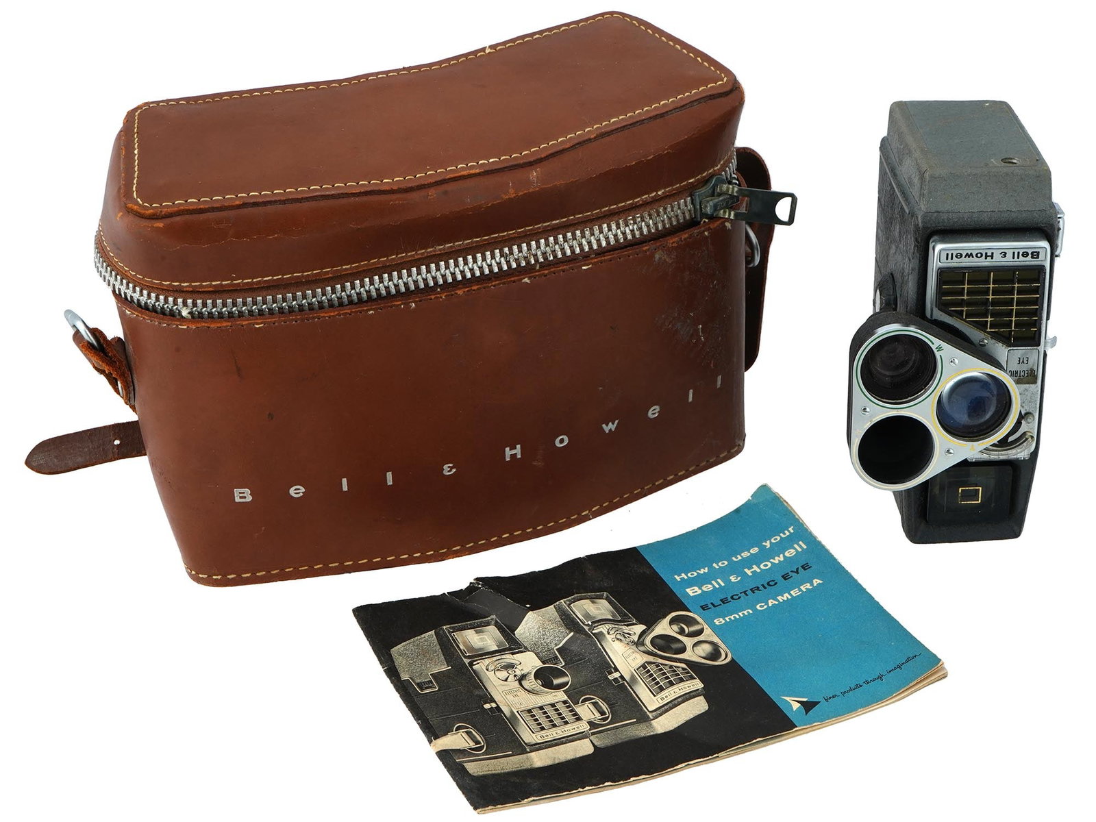 VINTAGE AMERICAN BELL AND HOWELL 8MM VIDEO CAMERA: A vintage American Bell and Howell 8mm video camera, with its original leather carrying case and instruction manual. The camera is black with silver accents and features a single viewfinder lens and a