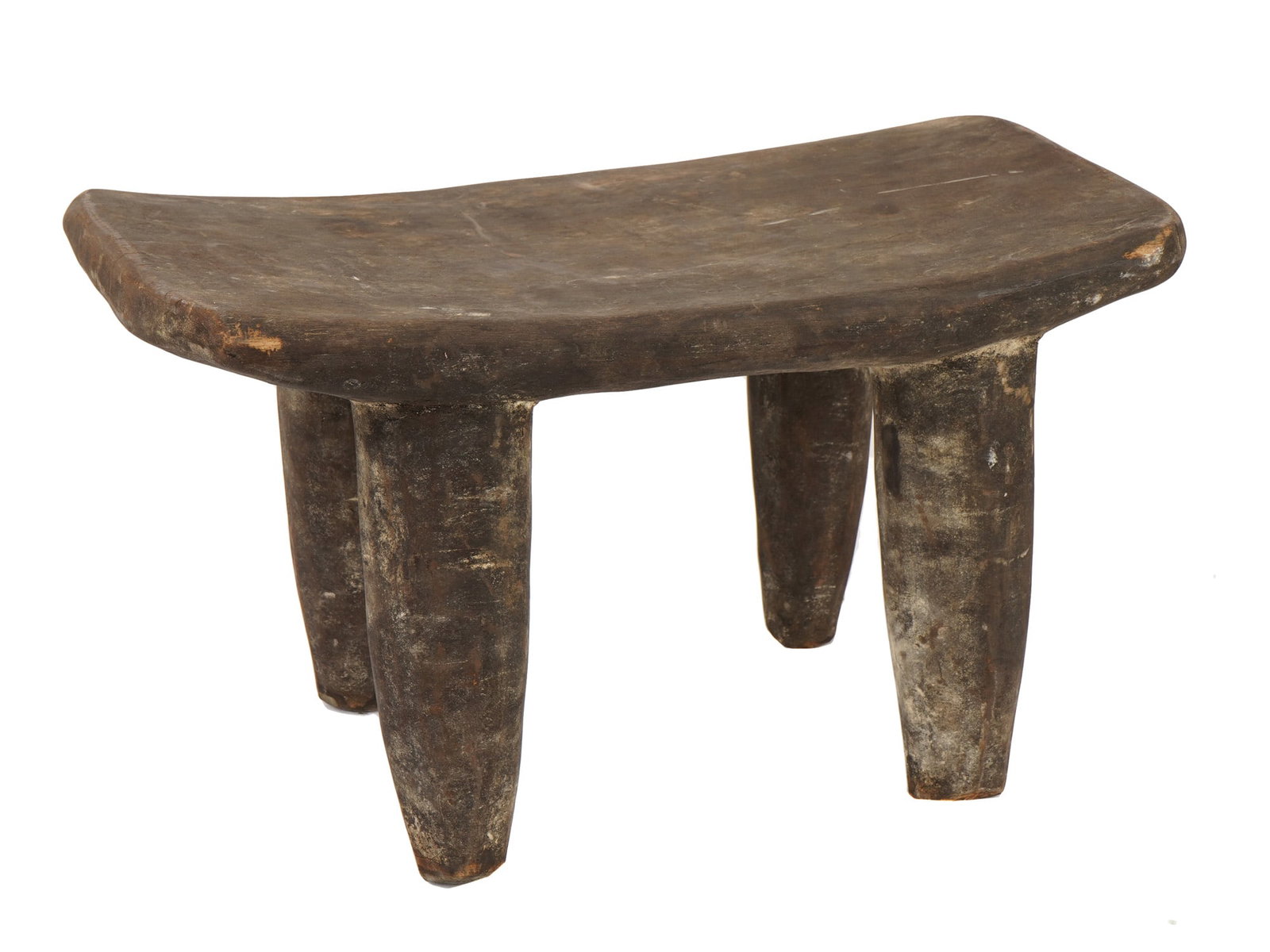 AFRICAN SENUFO HAND CARVED WOODEN DINNER STOOL: An African Senufo hand-carved wooden stool from the Ivory Coast, featuring a rectangular, slightly concave seat supported by four sturdy, tapered legs. The piece demonstrates the minimalist aesthetic 
