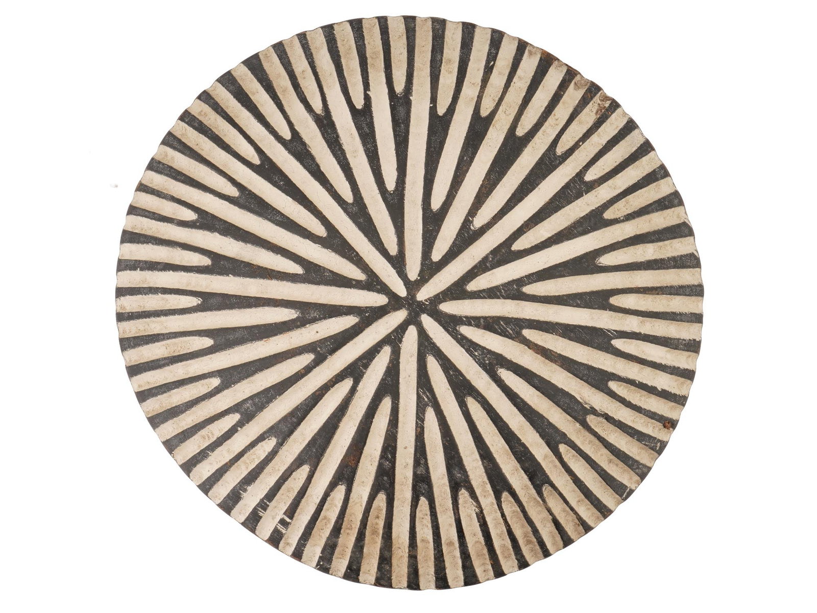 AFRICAN WOODEN BAMILEKE TRADITIONAL SHIELD CAMEROON: An African Bamileke traditional shield from Cameroon, hand-carved from a single piece of wood and historically used as a defensive object by tribal warriors. The surface features a bold starburst geom