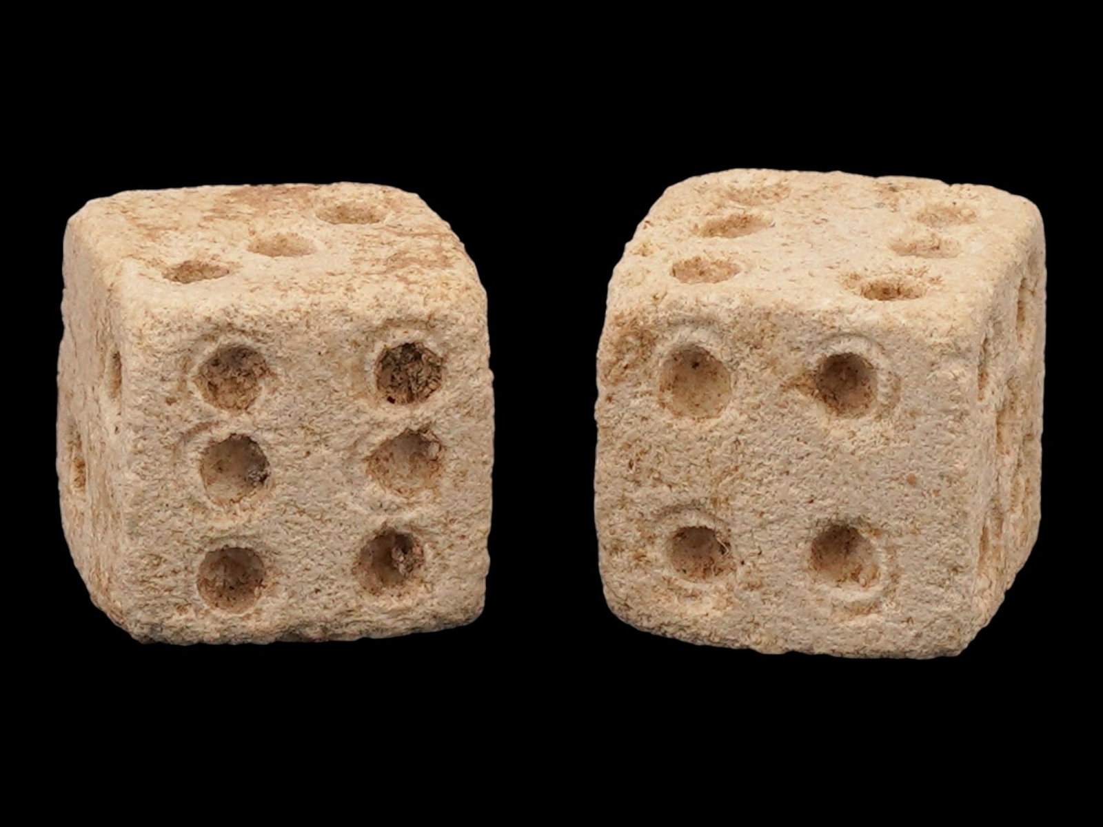 PAIR OF ANCIENT ROMAN CARVED STONE DICE: A pair of ancient Roman carved stone dice dating approximately from 300 to 100 AD. Finely shaped with incised numerical markings, these small gaming artifacts reflect the popularity of games of chance