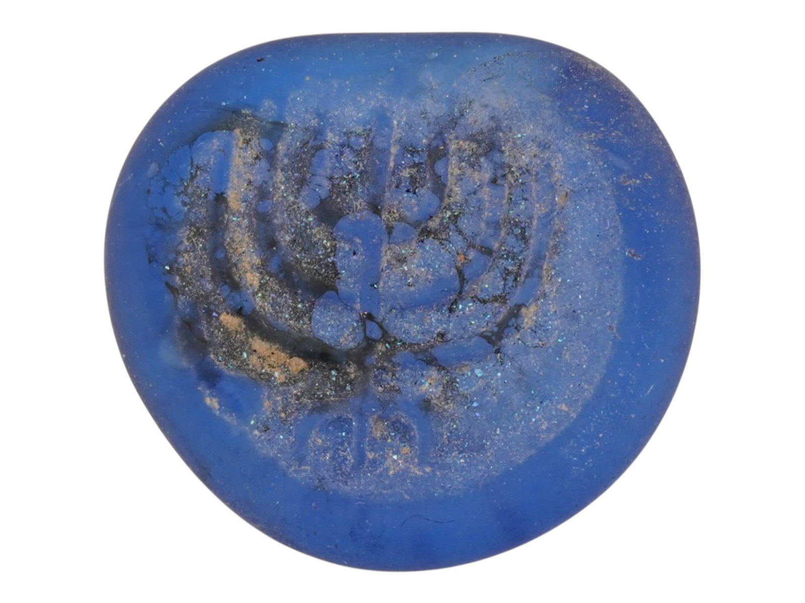 ANCIENT ROMAN BLUE GLASS MEDALLION W IMAGE OF A MENORAH: An ancient Roman blue glass medallion, dating circa 100 to 300 AD and featuring the image of a menorah rendered in relief. Crafted in blue glass, the piece reflects the artistic and religious symbolis