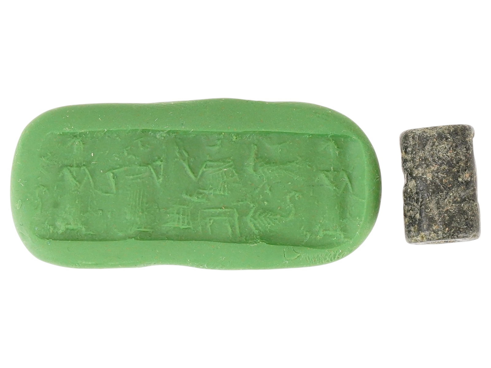 ANCIENT NEAR EASTERN STEATITE CYLINDER SEAL: An ancient Near Eastern steatite cylinder seal, dating from the 2nd to 1st millennium BC, engraved with ritualistic scenes depicting figures and symbolic motifs associated with ceremonial or religious