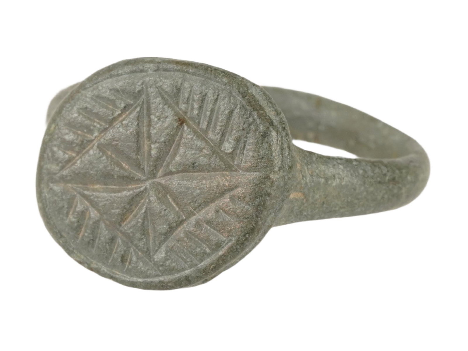 ANCIENT BYZANTINE BRONZE RING ENGRAVED W CROSS: An ancient Byzantine bronze ring, dated circa 400 to 600 AD. The ring features a circular bezel engraved with a geometric star or cross motif. The design is typically framed by notched or ray-like bor