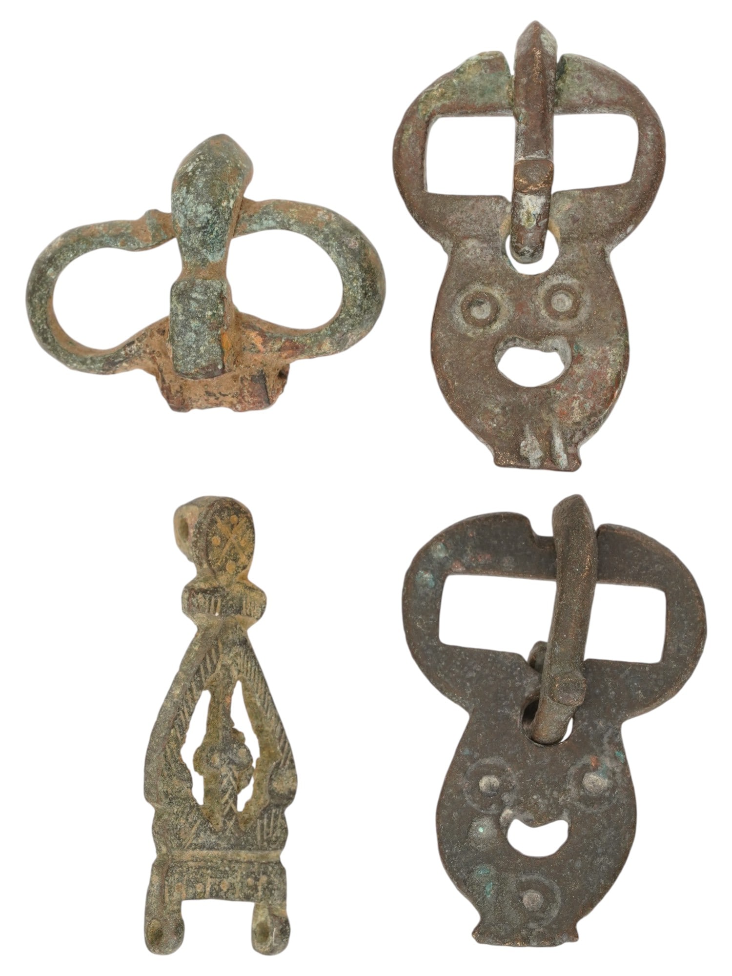 FOUR ANCIENT ROMAN AND BYZANTINE BRONZE BELT BUCKLES: A group of four ancient Roman and Byzantine bronze belt buckles dating from approximately 100 to 600 AD. The two buckles feature theatrical masks. One buckle is adorned with an engraved design. Ancien