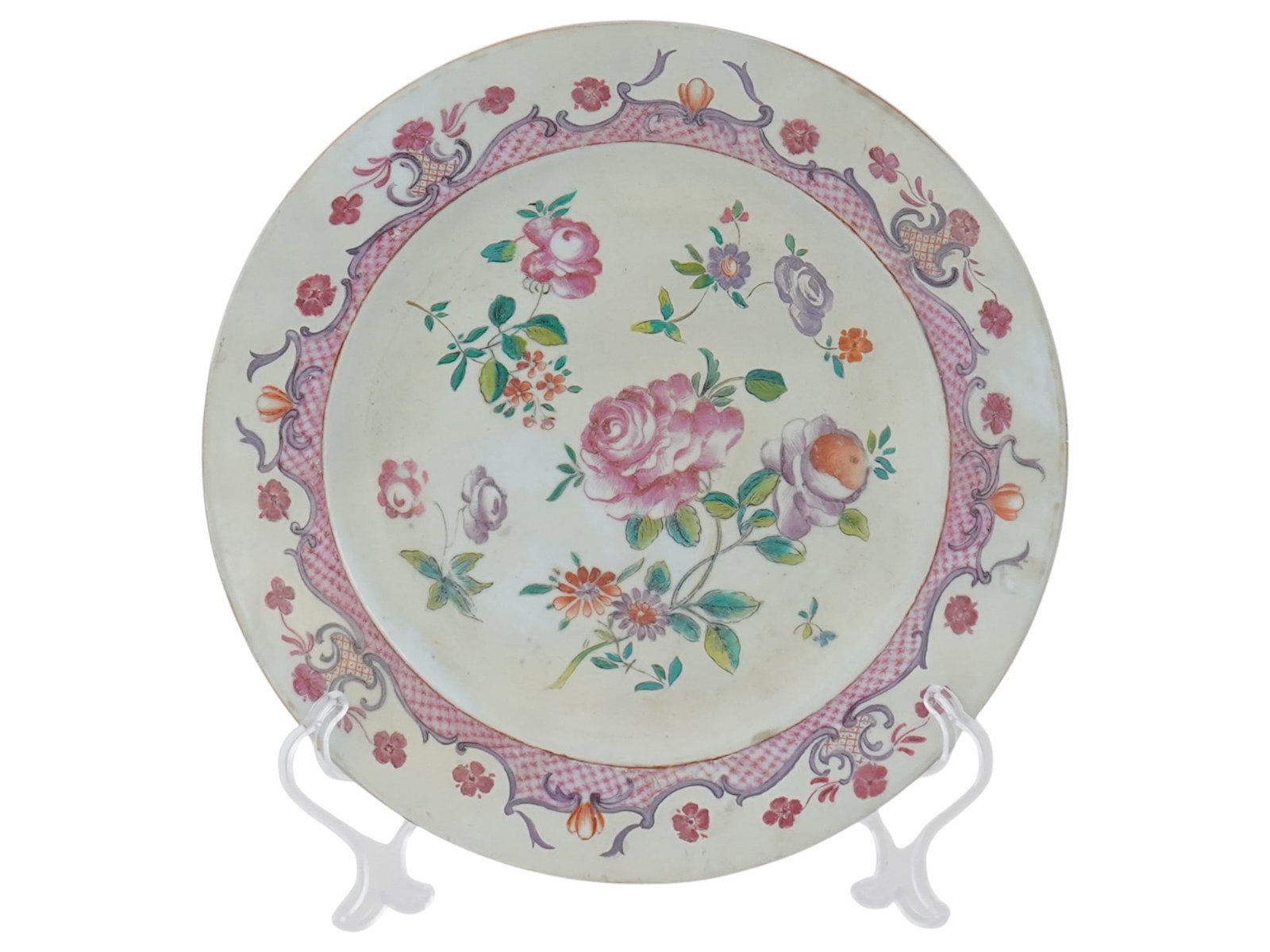 ANTIQUE CHINESE EXPORT FAMILLE ROSE PORCELAIN PLATE: An antique Chinese Export, early Famille Rose porcelain plate for the Continental European Market. The plate is adorned with a hand painted image of roses and other flowers in the center, and floral, 