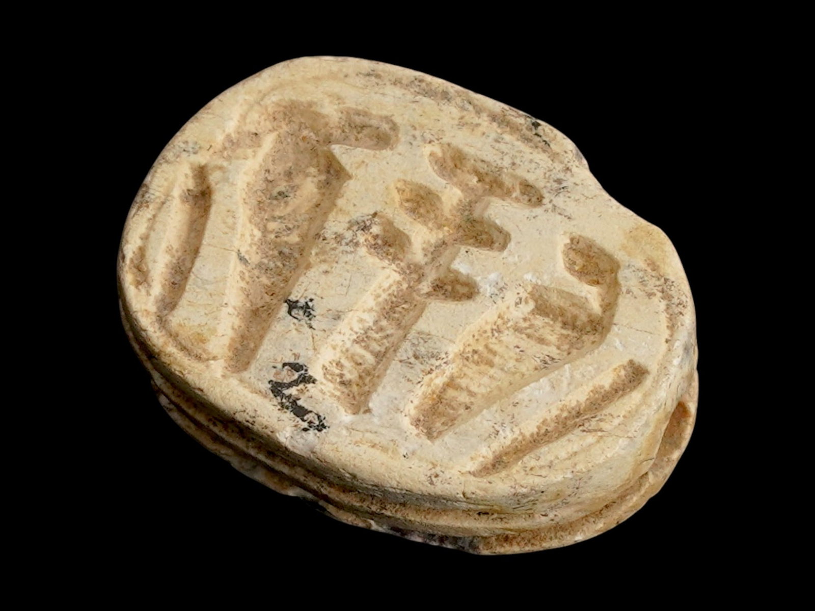 ANCIENT EGYPTIAN LATE PERIOD STEATITE SCARAB BEAD: An Ancient Egyptian carved steatite bead representing a scarab. Late Period, 26th Dynasty to Ptolemaic Egypt, ca. 700 to 200 BC. Carved Uraeus, the divine Egyptian cobra, on the bottom. In Egyptian my