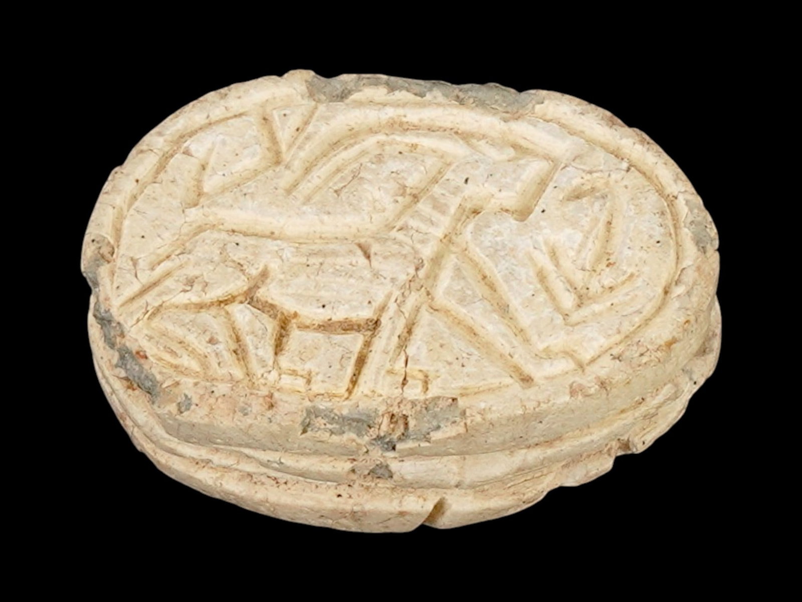 ANCIENT EGYPTIAN LATE PERIOD STEATITE SCARAB BEAD: An Ancient Egyptian carved steatite bead representing a scarab. Late Period, 26th Dynasty to Ptolemaic Egypt, ca. 700 to 200 BC. Carved deer and sacred lotus on the bottom. In Egyptian mythology, scar