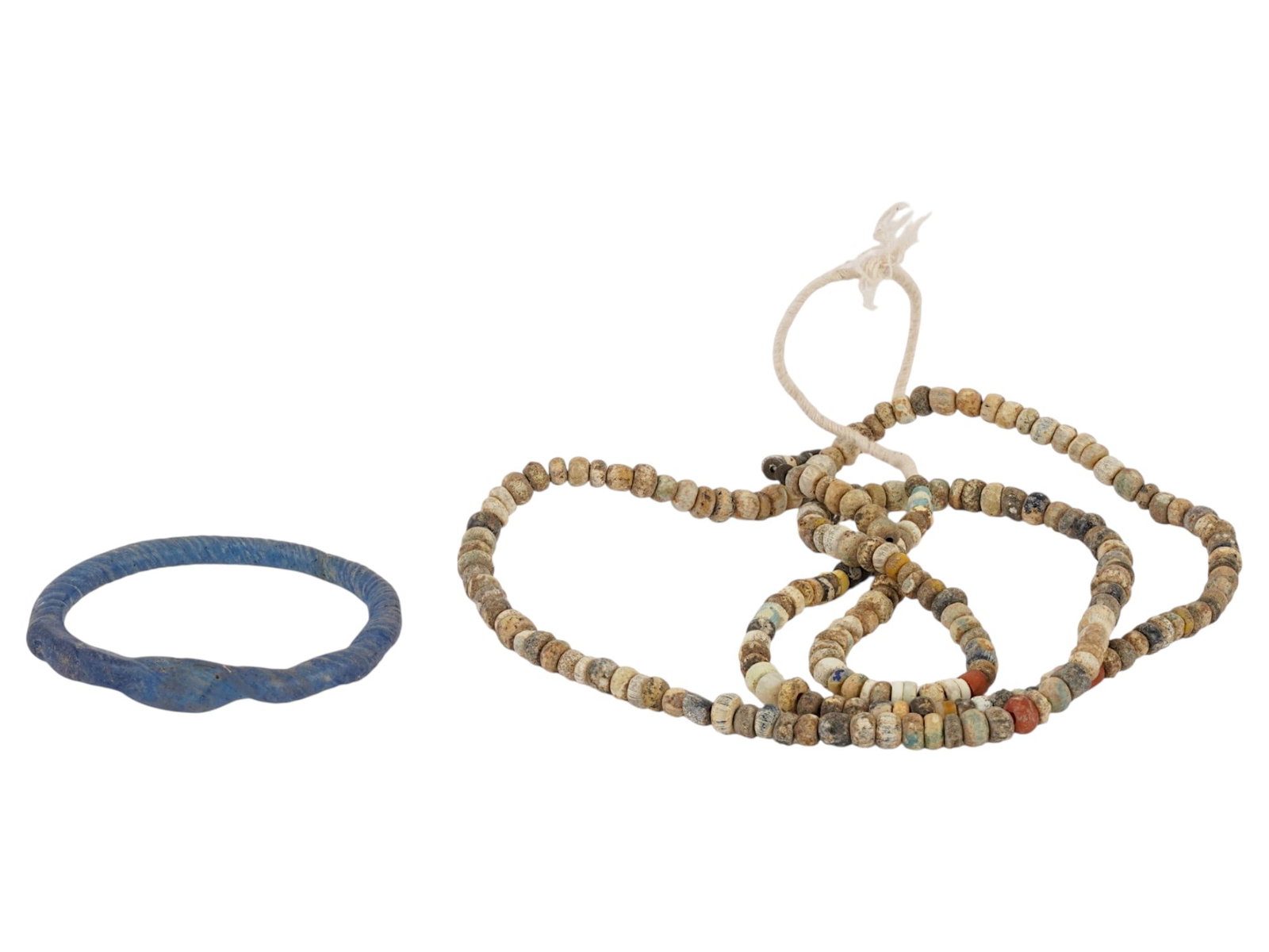 ANCIENT ROMAN EMPIRE GLASS BRACELET AND BEADED NECKLACE: A pair of Ancient Roman glass jewelry. Imperial Rome era, ca. 100 to 300 AD. Multicolor glass beaded necklace on a string. Twisted blue glass bangle bracelet. Historical Finds And Archaeological Relic