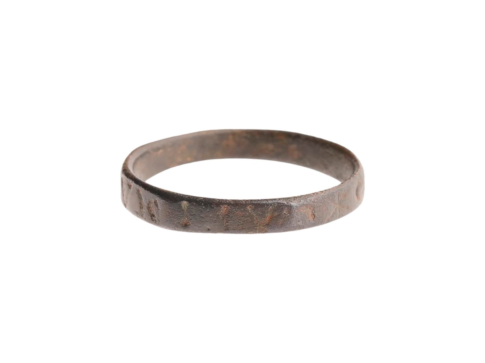 ANCIENT ROMAN BRONZE INSCRIBED RING 100 TO 300 AD: An ancient Roman bronze ring, dating circa 100 to 300 AD, features a continuous flat band design. The exterior surface is decorated with an incised epigraphic inscription, likely representing a protec