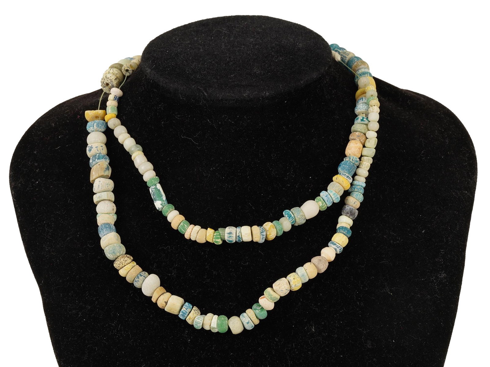 ANCIENT ROMAN MULTICOLOR GLASS BEAD NECKLACE: An ancient Roman necklace crafted from multicolored glass beads, dating from 100 to 300 AD. The necklace showcases a range of bead colors, mostly circular shaped, reflecting the Roman eras intricate g