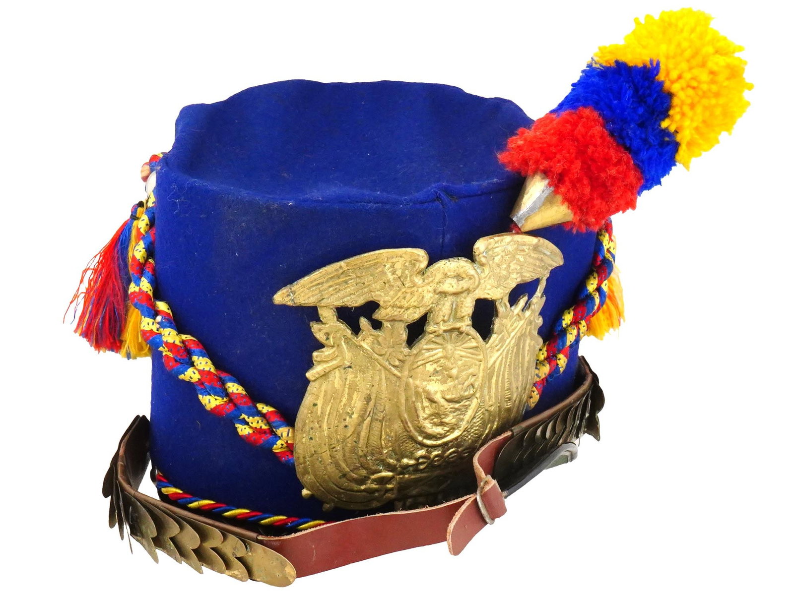 VINTAGE ECUADORIAN TARQUI GRENADIERS TOY HELMET: A vintage Ecuadorian Tarqui grenadiers toy helmet. The soft blue fabric toy helmet with a gilt coat of arms, multicolored pom poms and twisted cord. Complete with a strap with scale decor at the lower