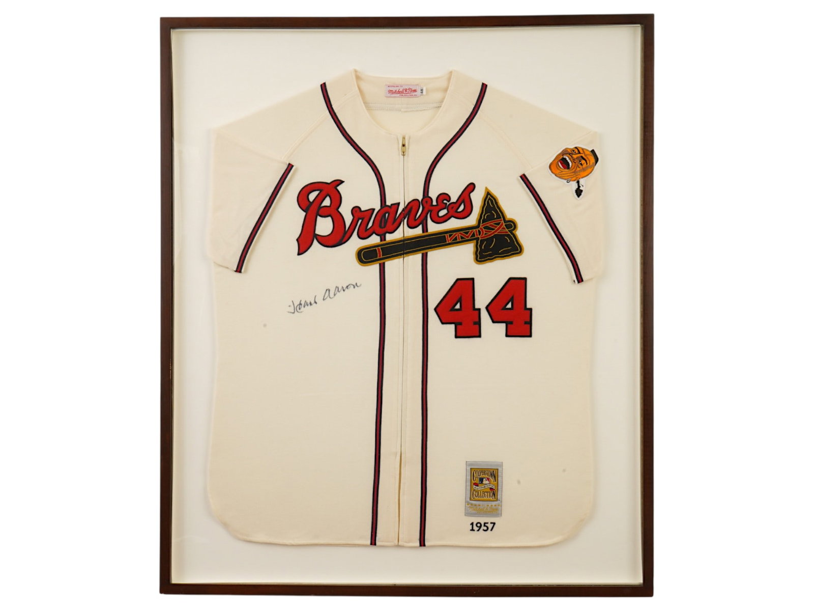 HANK AARON SIGNED BRAVES MITCHELL NESS FRAMED JERSEY: A professionally framed Milwaukee Braves Mitchell & Ness Cooperstown Collection jersey hand-signed by Home Run King Hank Aaron. This premium display piece includes a certificate of authenticity. MLB,