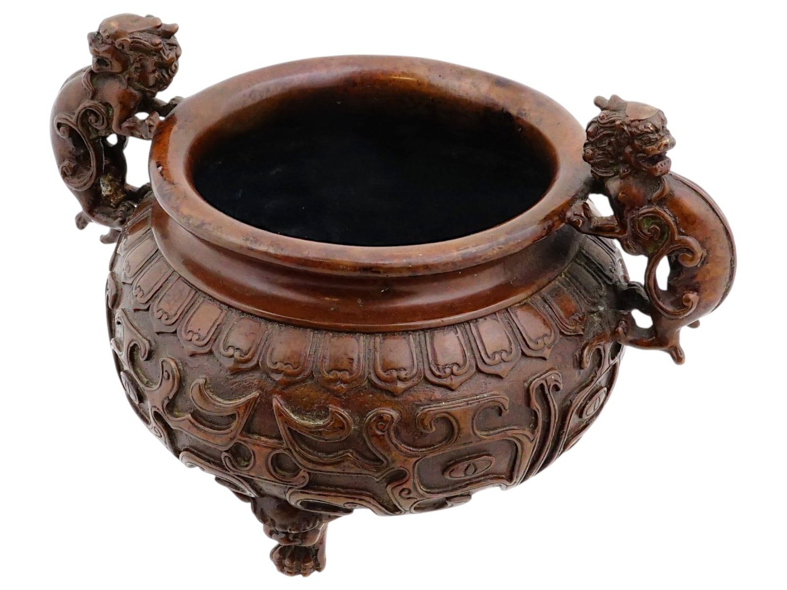 CHINESE TRIPOD BRONZE INCENSE BURNER WITH HANDLES: A Chinese bronze incense burner senser made in an archaic style. A ding or compressed gui vessel on three legs decorated with relief masks of mythical creatures. The ware is adorned with two massive h