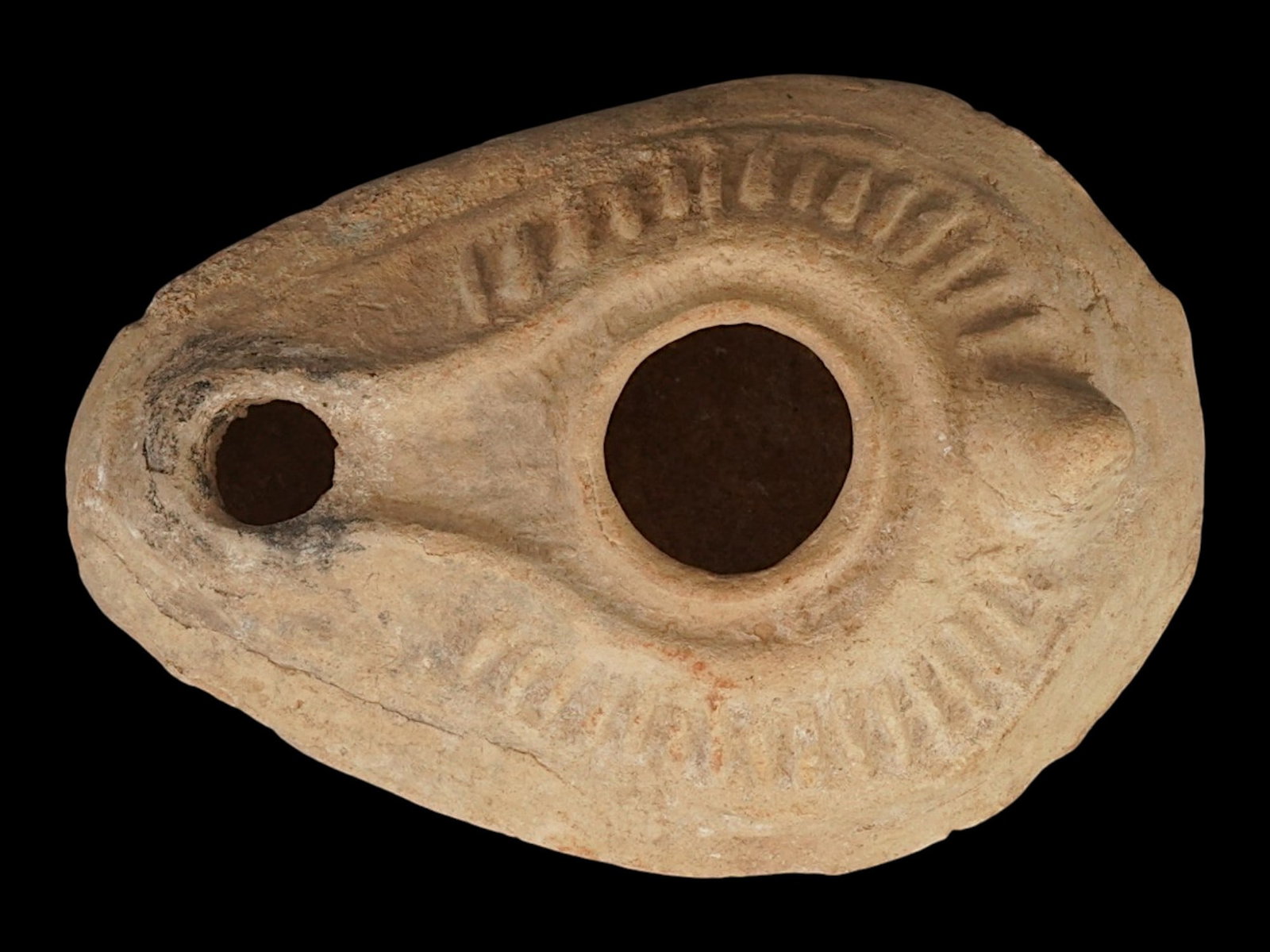 ANCIENT BYZANTINE TERRACOTTA OIL LAMP 400 TO 600 AD: An ancient Byzantine terracotta oil lamp dating circa 400 to 600 AD, illustrating the functional artistry of early Byzantine domestic life. Features the characteristic form, wreath design on the body 