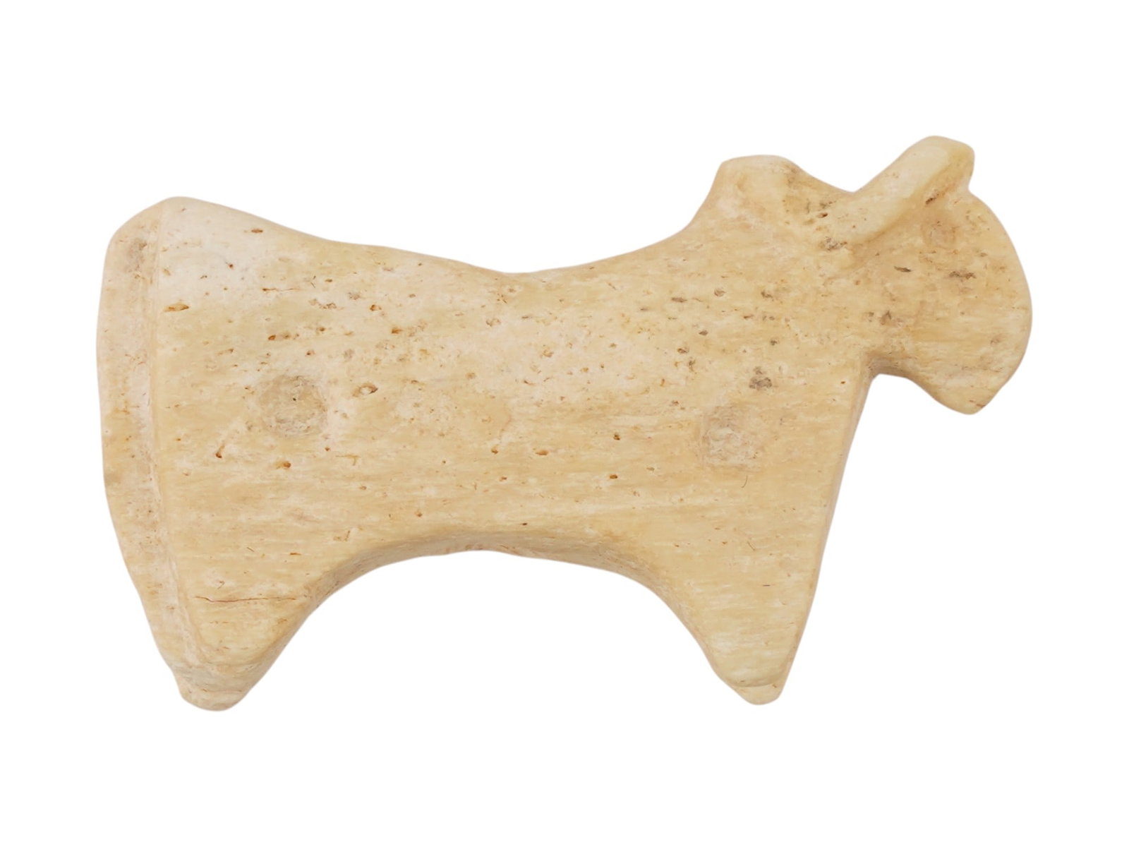 ANCIENT GREEK SOFT STONE BULL PENDANT CA 600 TO 400 BC: An ancient Greek bull pendant carved of soft stone, dating to circa 600 to 400 BC. The pendant features a highly stylized, schematic representation of a bull with short, tapered legs and distinct horn