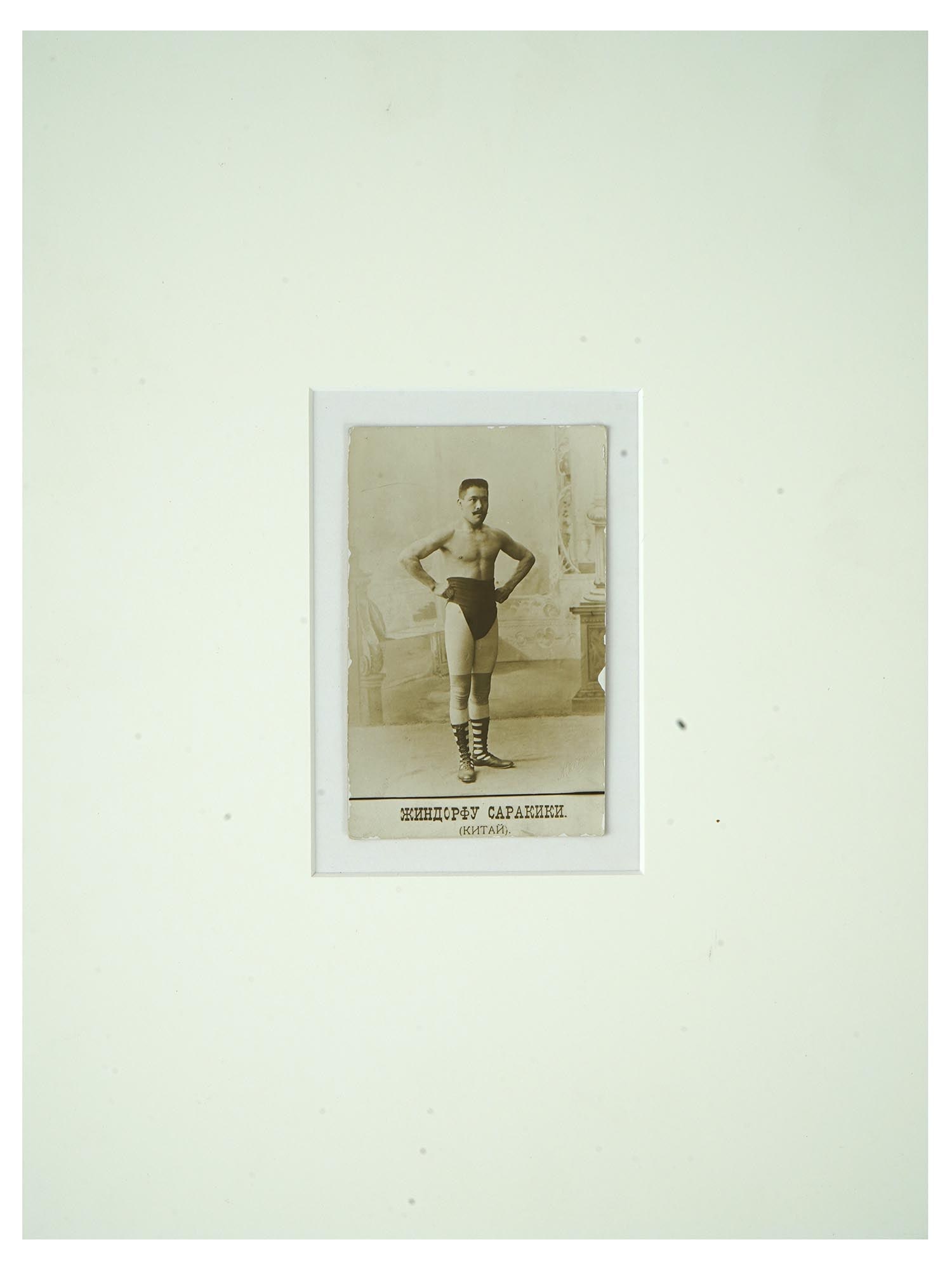ANTIQUE RUSSIAN PORTRAIT PHOTO OF JAPANESE WRESTLER: An antique Russian post card with a black and white photograph, depicting a studio portrait of Sarakiki Jindofu, a Japanese wrestler. Circa: early 20th century. Titled, Sarakiki Jindofu, China, lower 