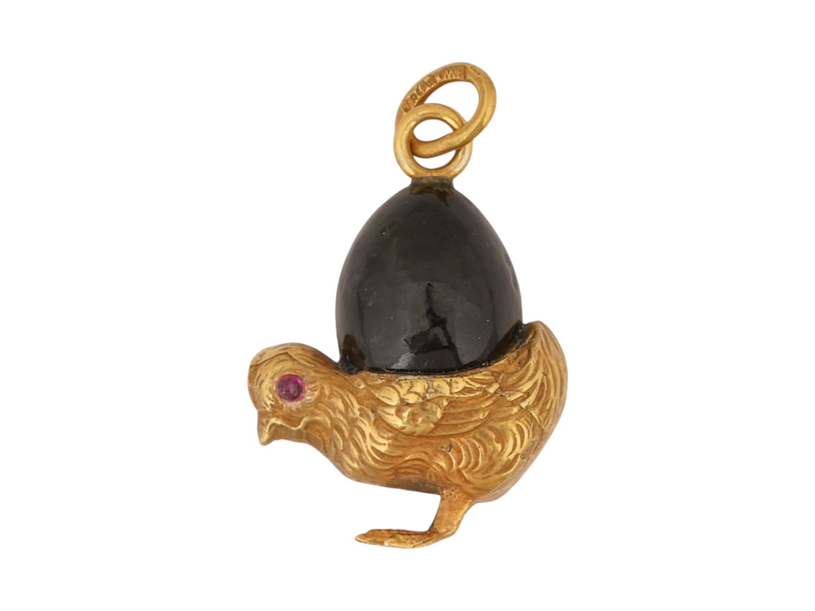 RUSSIAN SILVER JADE CHICK EGG PENDANT W RUBY EYES: A Russian gilt silver pendant modeled as a chick with eyes set with ruby cabochons holding a carved black jade egg. Finely detailed with carved patterns. Hallmarked with an 88 Russian silver standard 