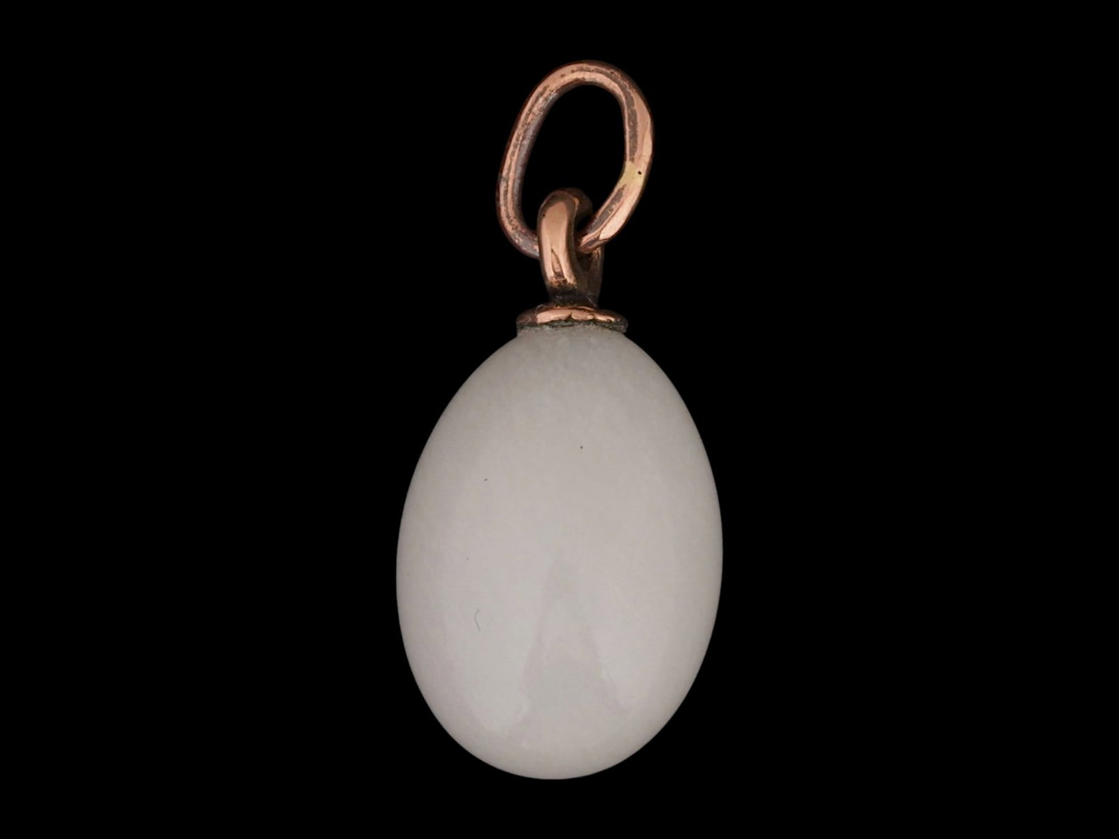 RUSSIAN GOLD AND CARVED WHITE JADE EASTER EGG PENDANT: A Russian carved white jade Easter egg pendant with a gold loop and a gold suspension ring hallmarked with the 56 Russian gold standard proof and the manufacturer marks. Russian Stone ?arved Jewelry C