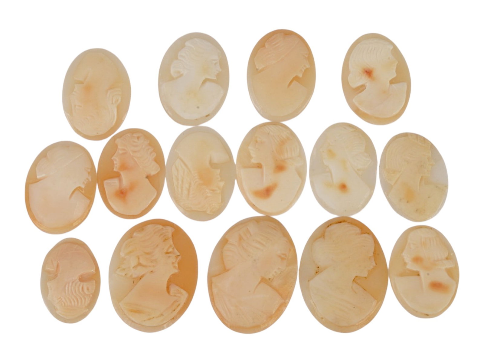 COLLECTION OF CARVED FEMALE PORTRAIT SHELL CAMEOS: A collection of hand carved shell cameos. A total of 15 items. Each piece depicts a female profile portrait rendered in high relief in the Victorian and Roman manners. Each cameo is fashioned in a dis
