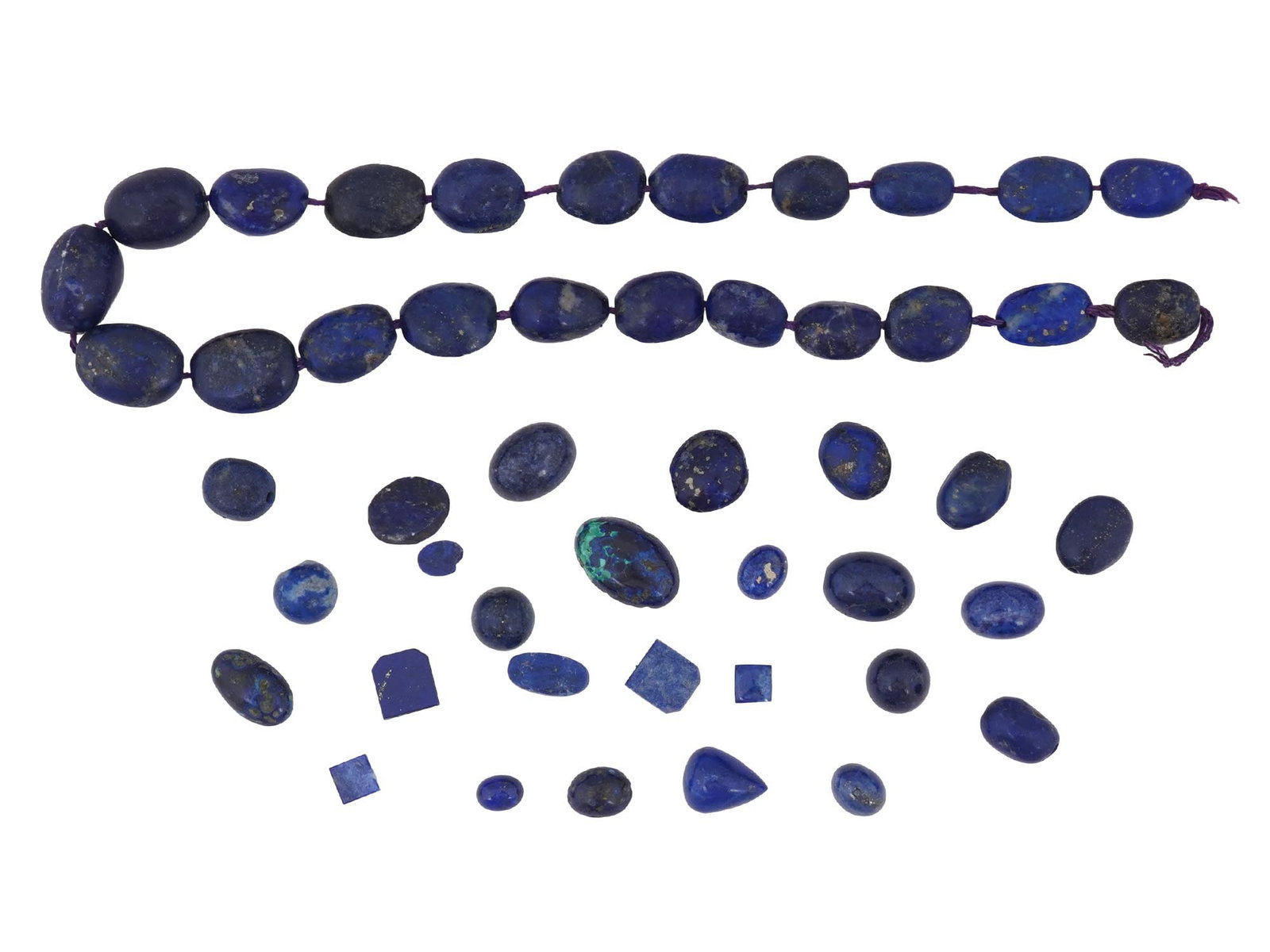 COLLECTION OF ASSORTED LAPIS LAZULI STONE BEADS: A collection of assorted carved Lapis Lazuli stone beads. The beads are made in various sizes and in oval, rectangular, drop and other shapes. The lot includes a string with oval form beads. Vintage J
