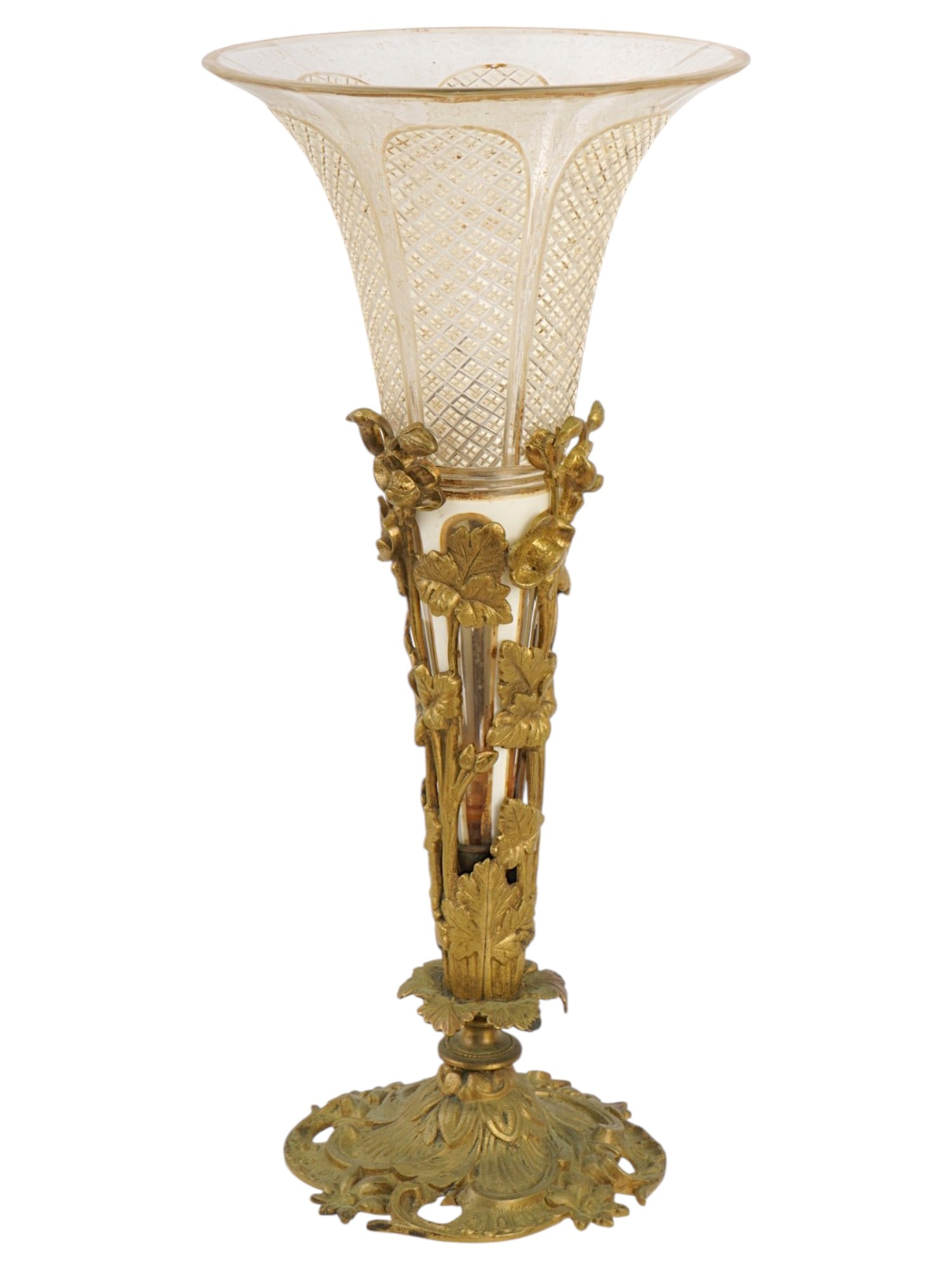 ANTIQUE FRENCH ART NOUVEAU BRASS AND GLASS TRUMPET VASE: An antique French Art Nouveau trumpet vase, featuring an ornate brass base with a lattice-patterned glass insert. Features organic, flowing floral and leaf motifs wrap around the stem and base, charac