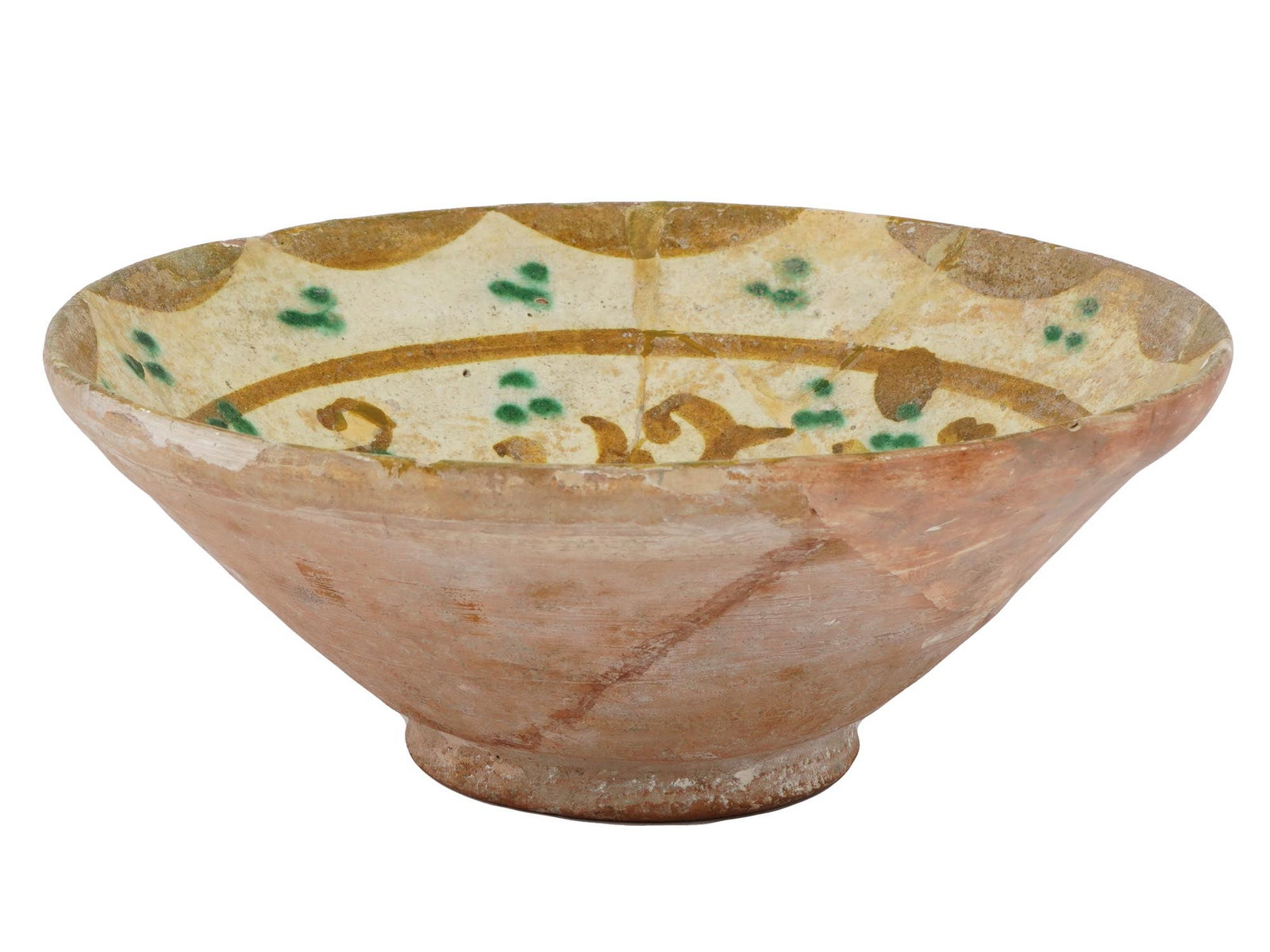 EARLY ISLAMIC PERSIAN NISHAPUR GLAZED POTTERY BOWL: An antique early Islamic Persian Nishapur glazed pottery bowl. The footed bowl is covered with glaze in brown, beige and green shades; and decorated with a foliage ornament and probably a Kufic callig