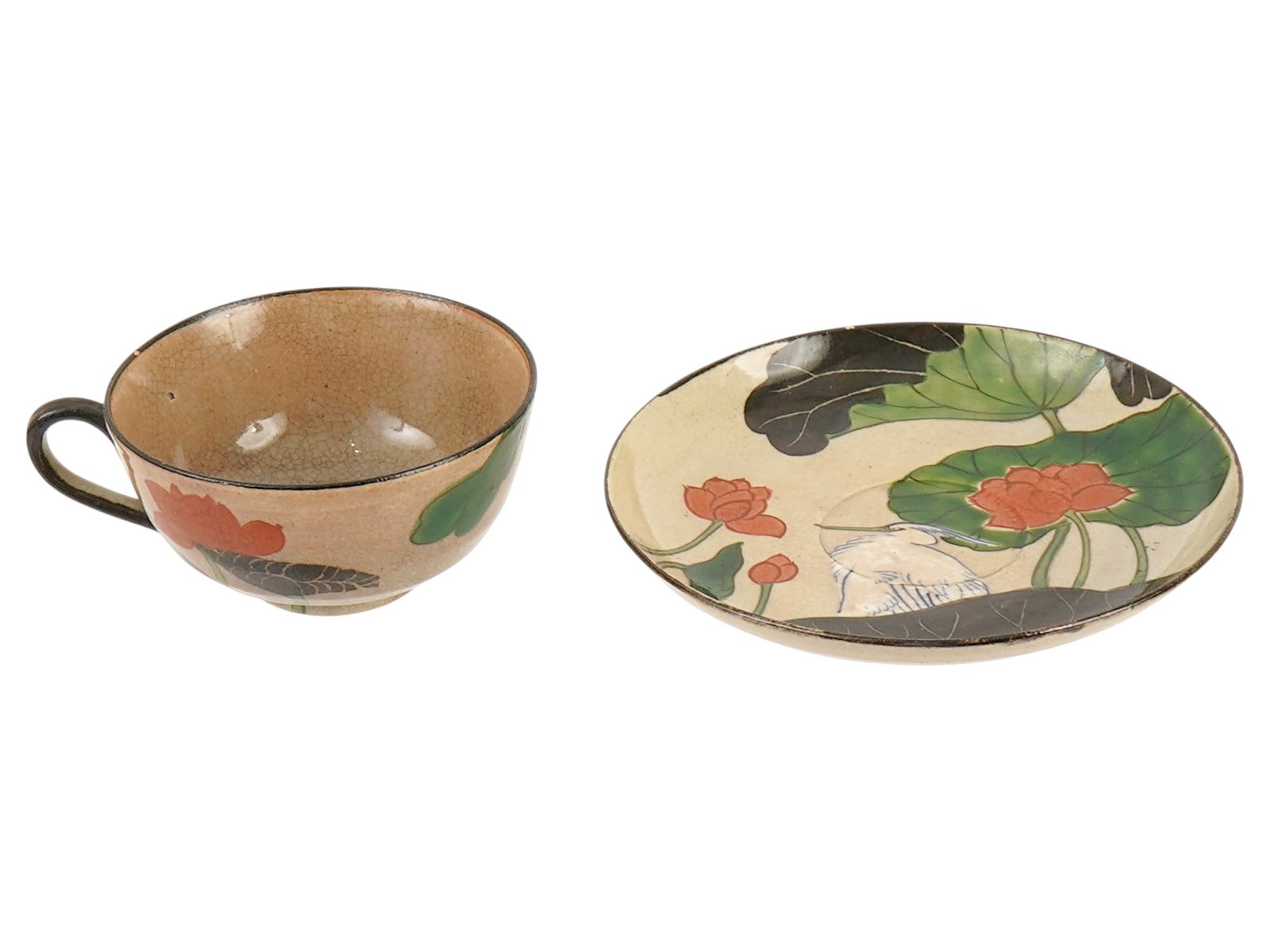 JAPANESE OGATA KENZAN CERAMIC CUP AND SAUCER: A vintage Japanese Ogata Kenzan, 1663 to 1743, style ceramic stoneware cup with a saucer. The set is decorated with aquatic plant and white heron motifs and is glazed. The bottom of both pieces bears 
