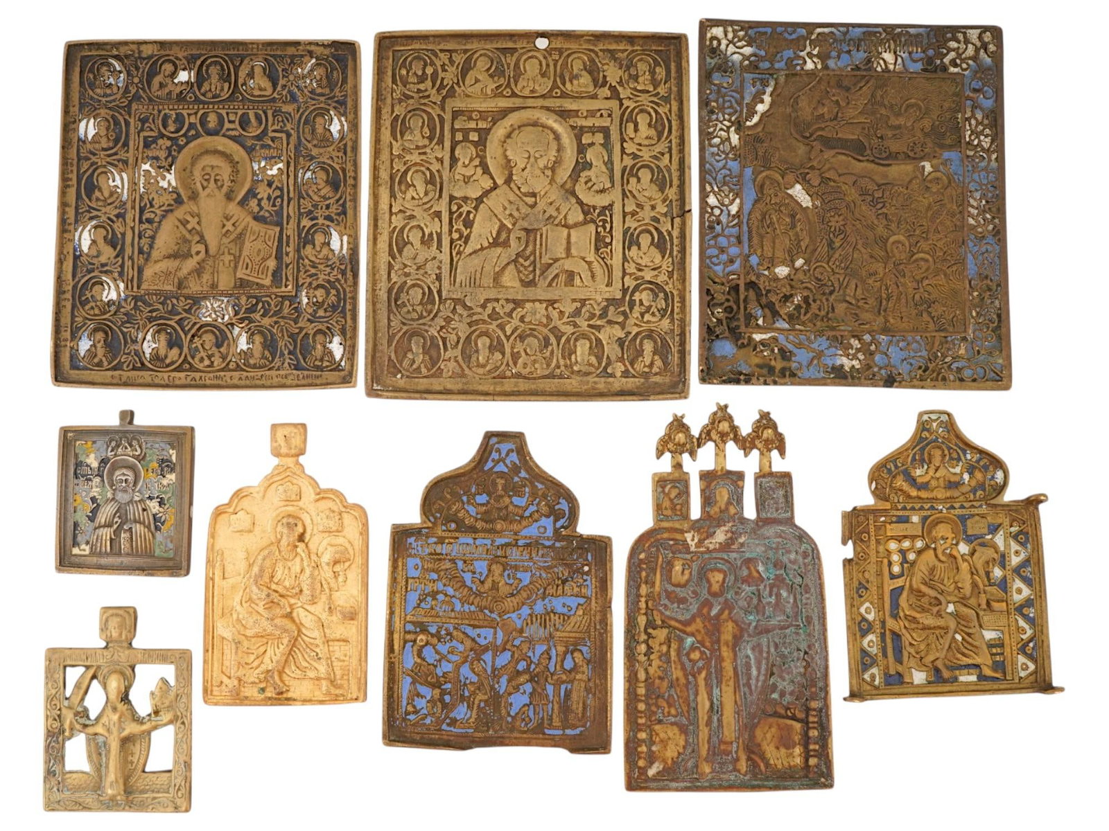 LOT OF ANTIQUE RUSSIAN ORTHODOX CAST BRONZE ICONS: A lot of ten antique 19th-century Russian Orthodox cast bronze icons. Some pieces are decorated with enamel. The lot includes images of Saint Nicholas of Myra, St John the Evangelist, scenes from the 