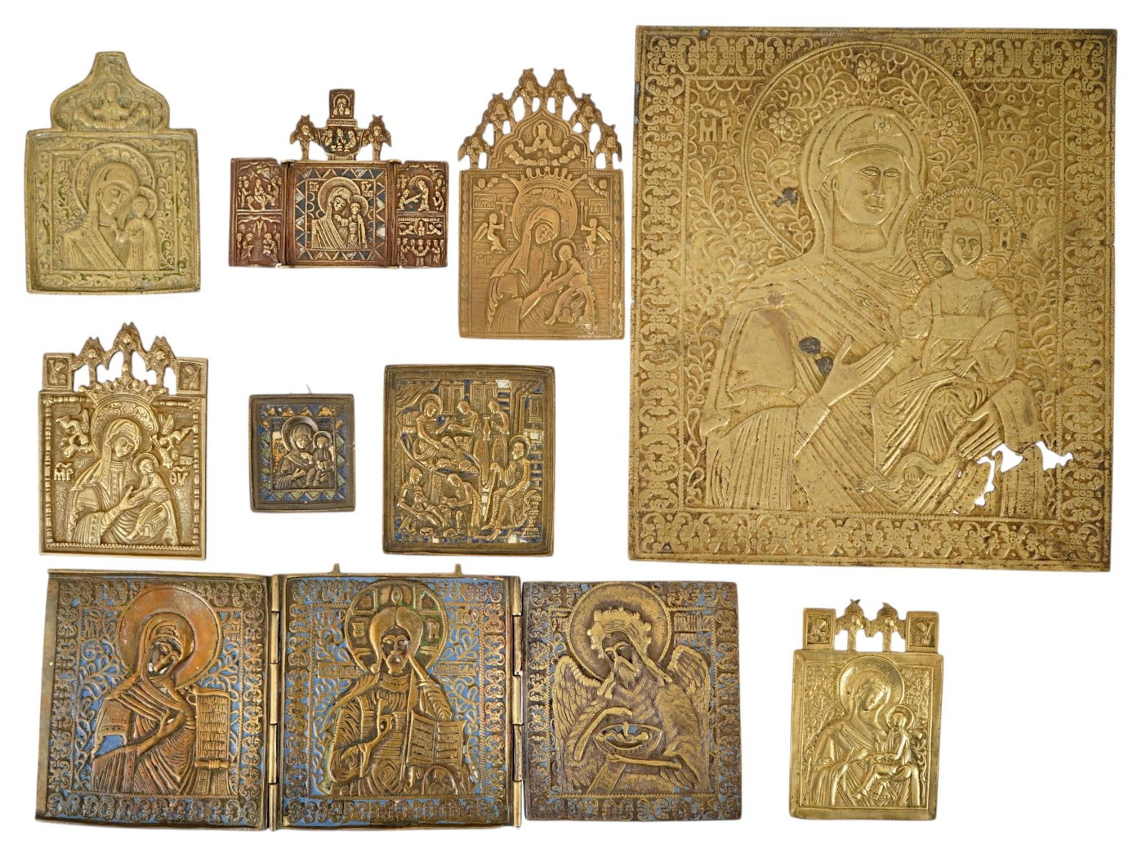 ANTIQUE RUSSIAN ORTHODOX BRONZE TRAVELING ICONS: A group of antique Russian Orthodox bronze traveling icons, dating to the 19th century, enriched with vibrant vitreous enamel. The collection includes traditional subjects such as the Mother of God in