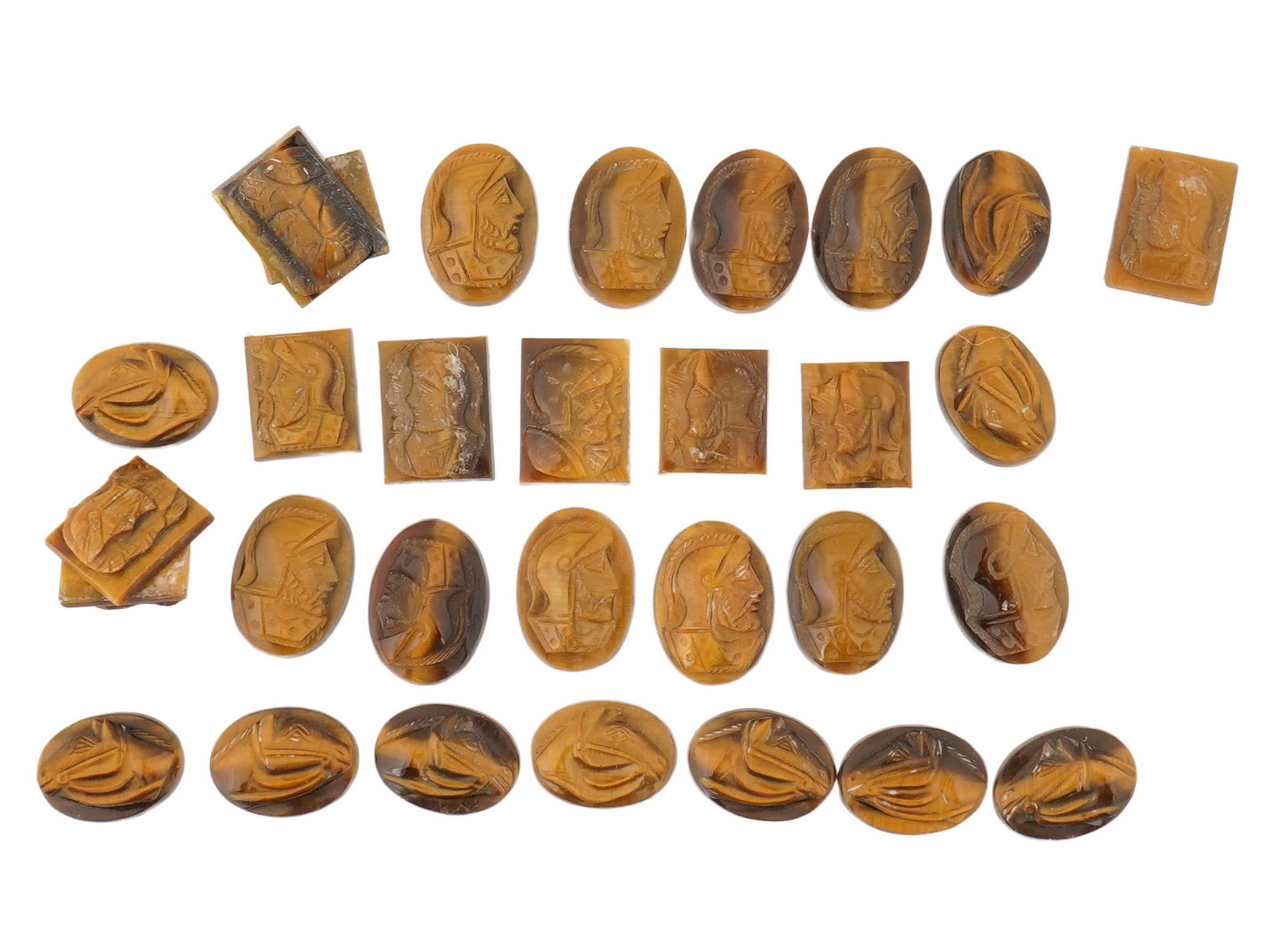 COLLECTION OF 30 VINTAGE CARVED TIGERS EYE CAMEOS: A collection of 30 vintage tigers eye cameos, consisting of small carved stones displaying the gemstones characteristic golden-brown, chatoyant appearance. Each piece is carved in relief, primarily