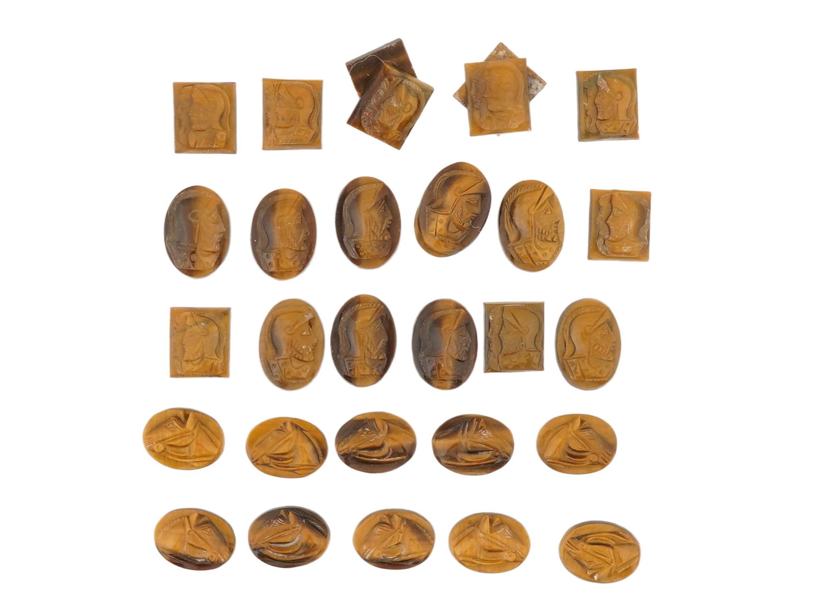 COLLECTION OF 30 VINTAGE CARVED TIGERS EYE CAMEOS: A collection of 30 vintage tigers eye cameos, consisting of small carved stones displaying the gemstones characteristic golden-brown, chatoyant appearance. Each piece is carved in relief, primarily