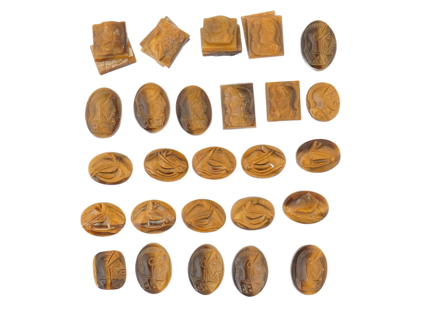 COLLECTION OF PORTRAIT CARVED TIGERS EYE CAMEOS: A collection of hand carved tigers eye cameos. A total of 30 items. Each piece features a knight and a horse profile portrait rendered in high relief. Square and oval shape. Collectible Jewelry And