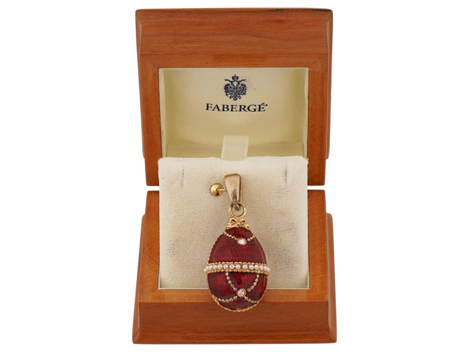 RUSSIAN SILVER ENAMEL EGG PENDANT W RHINESTONES IN BOX: A Russian gilt silver egg pendant, crafted with translucent red guilloche enamel and accented with rhinestones and seed pearls. It is detailed with a horizontal band of seed pearls and intersecting