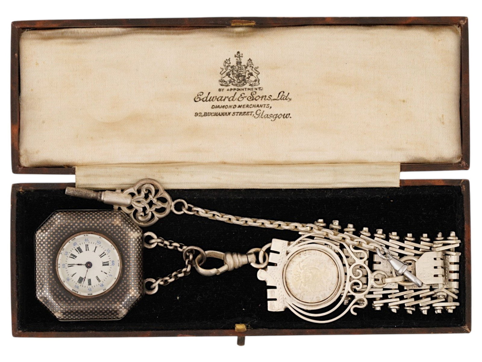 RUSSIAN SILVER FOB DIAMOND WATCH AND CHATELAINE SET: A Russian silver fob watch and chatelaine set. The hexagonal watch case is decorated with textured silverwork and rose-cut diamond accents, forming the Russian double-headed eagle, enclosing a porcela