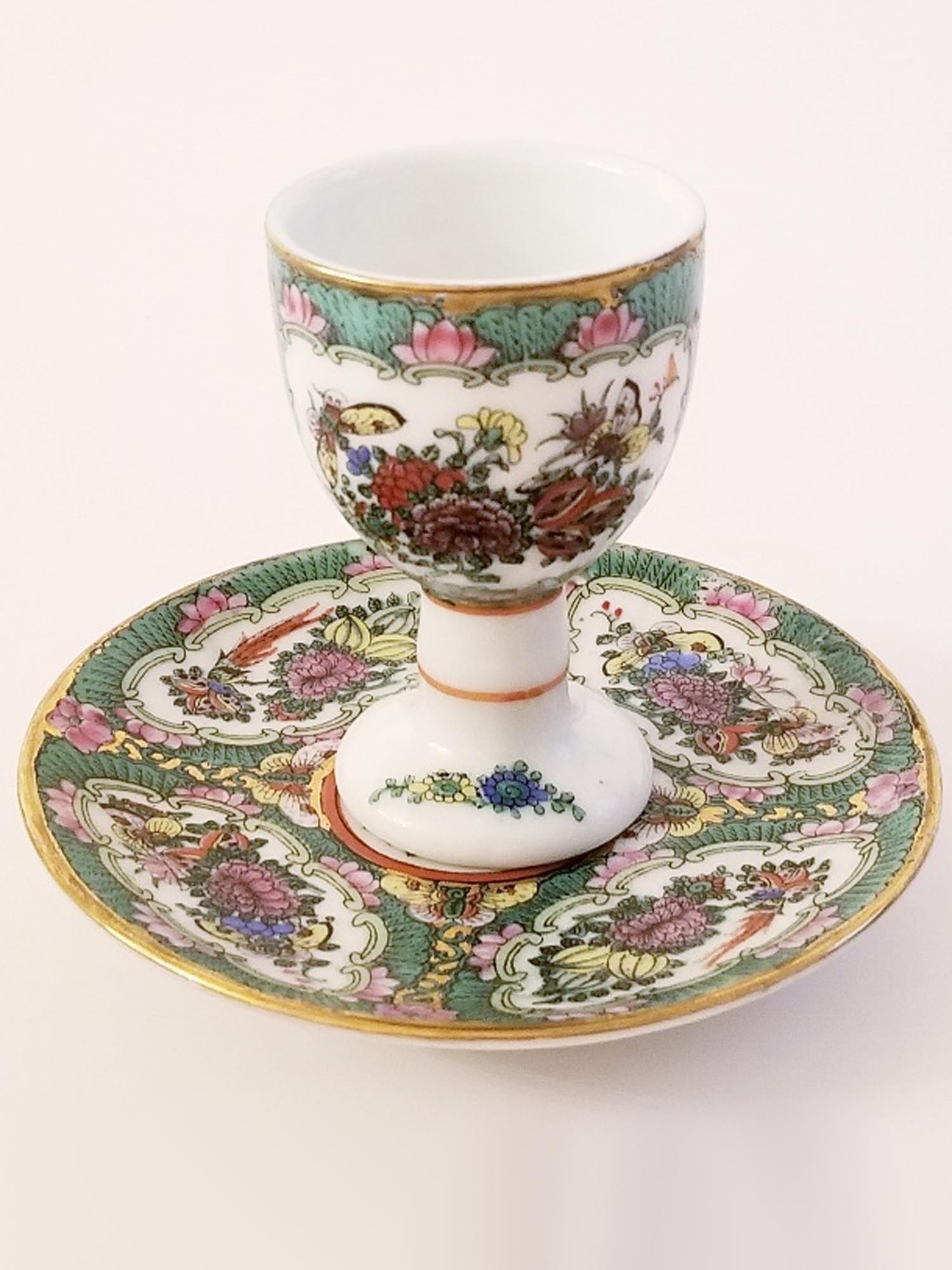 RUSSIAN SOVIET PORCELAIN EGG HOLDER AND SAUCER 1937: A rare Russian Soviet era egg holder with a matched saucer, circa 1937. Both pieces are hand painted with polychrome floral patterns and cartouches with intricate flower arrangements. The cup is