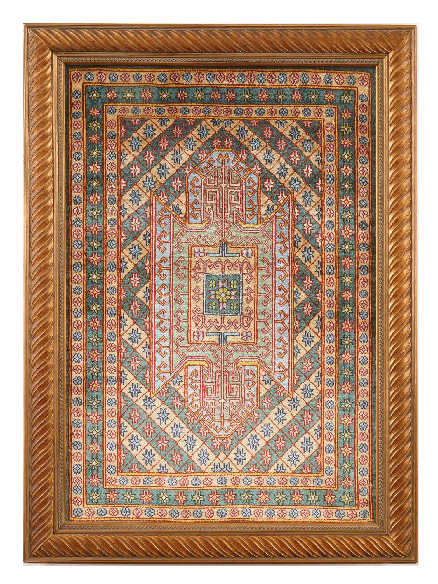 MIDDLE EASTERN PERSIAN HAND KNOTTED SILK RUG FRAMED: A Persian silk rug featuring an intricate geometric composition centered around a rectangular medallion with a cruciform motif. The field is decorated with diagonal bands of stylized floral and foliat