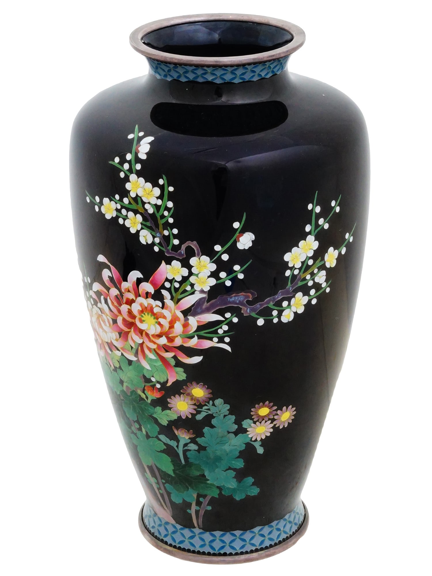 JAPANESE FLOWERS CLOISONNE ENAMEL OVER COPPER VASE: A Japanese enamel over copper dark blue vase. The vase has an urn shaped body and a wide neck with a fluted mouth. The vase is enameled with a polychrome design representing blossoming flowers made in