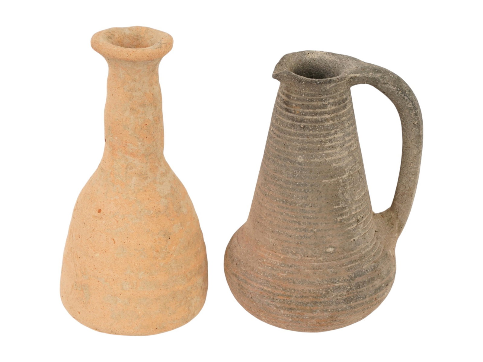 ANCIENT ROMAN TERRACOTTA PITCHER BOTTLE 100 TO 300 AD: A group of an ancient Roman terracotta pottery wine pitcher and a bottle, dating circa 100 to 300 AD. The wares are decorated with fluted mouthes. The pitcher is adorned with a ribbed design, and a cu