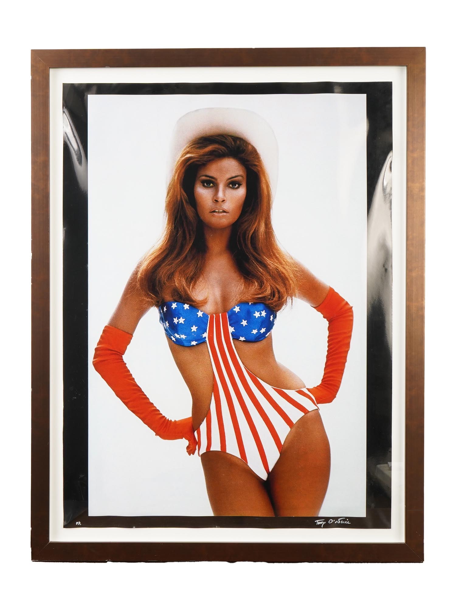 OVERSIZE RAQUEL WELCH PHOTO AUTOGRAPHED BY TERRY ONEILL: An oversize iconic color photo features American actress Raquel Welch as her character Myra Breckinridge from the 1970 comedy film of the same name. Raquel Welch poses in a stars and stripes swimsuit 