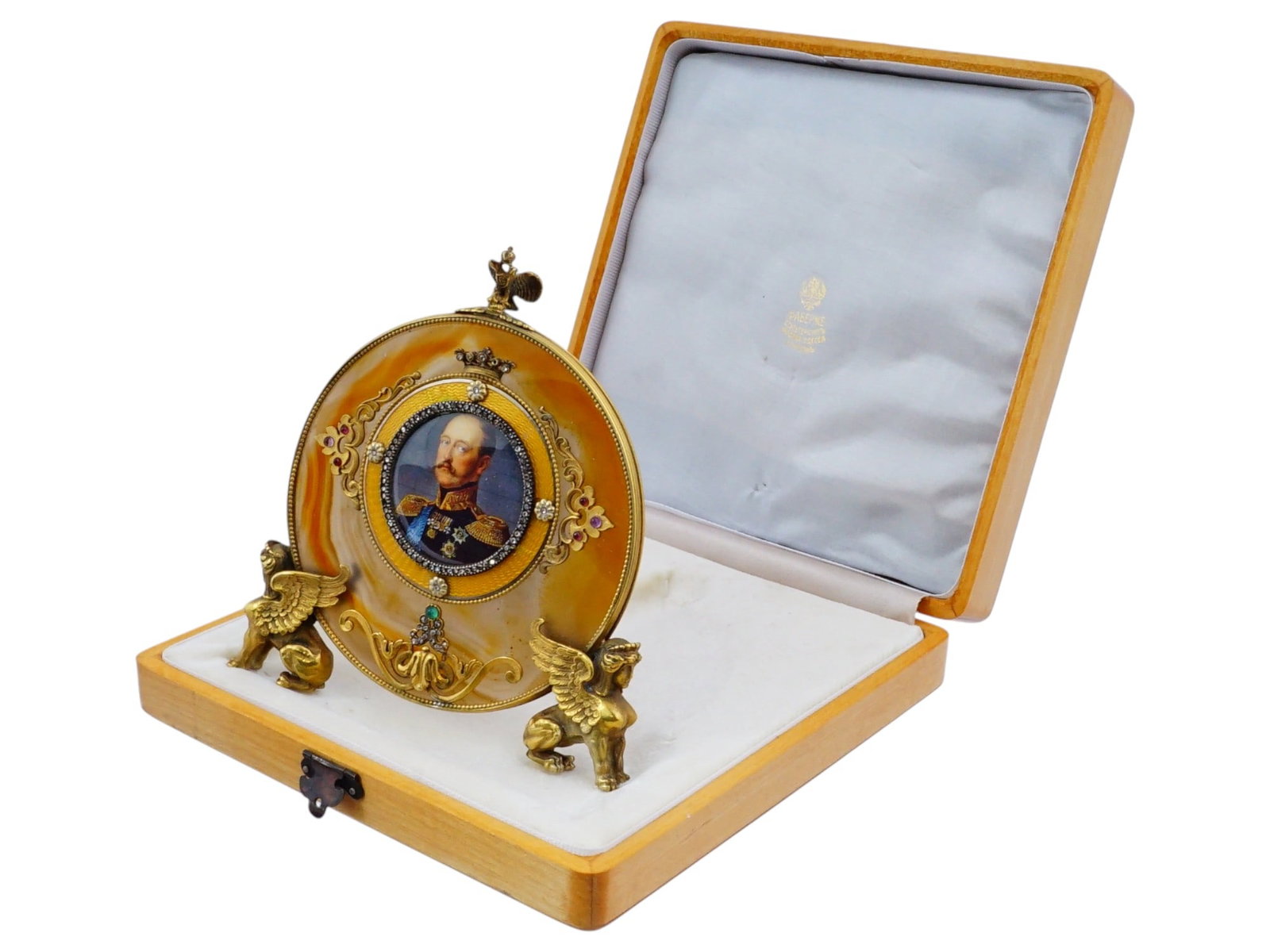 RUSSIAN SILVER ENAMEL DIAMOND AND AGATE PICTURE FRAME: A Russian 88 gilt Silver and enamel picture frame. The round shape is framed by a beautifully polished agate background, which gives it a rich and warm appeal. The central circular medallion features