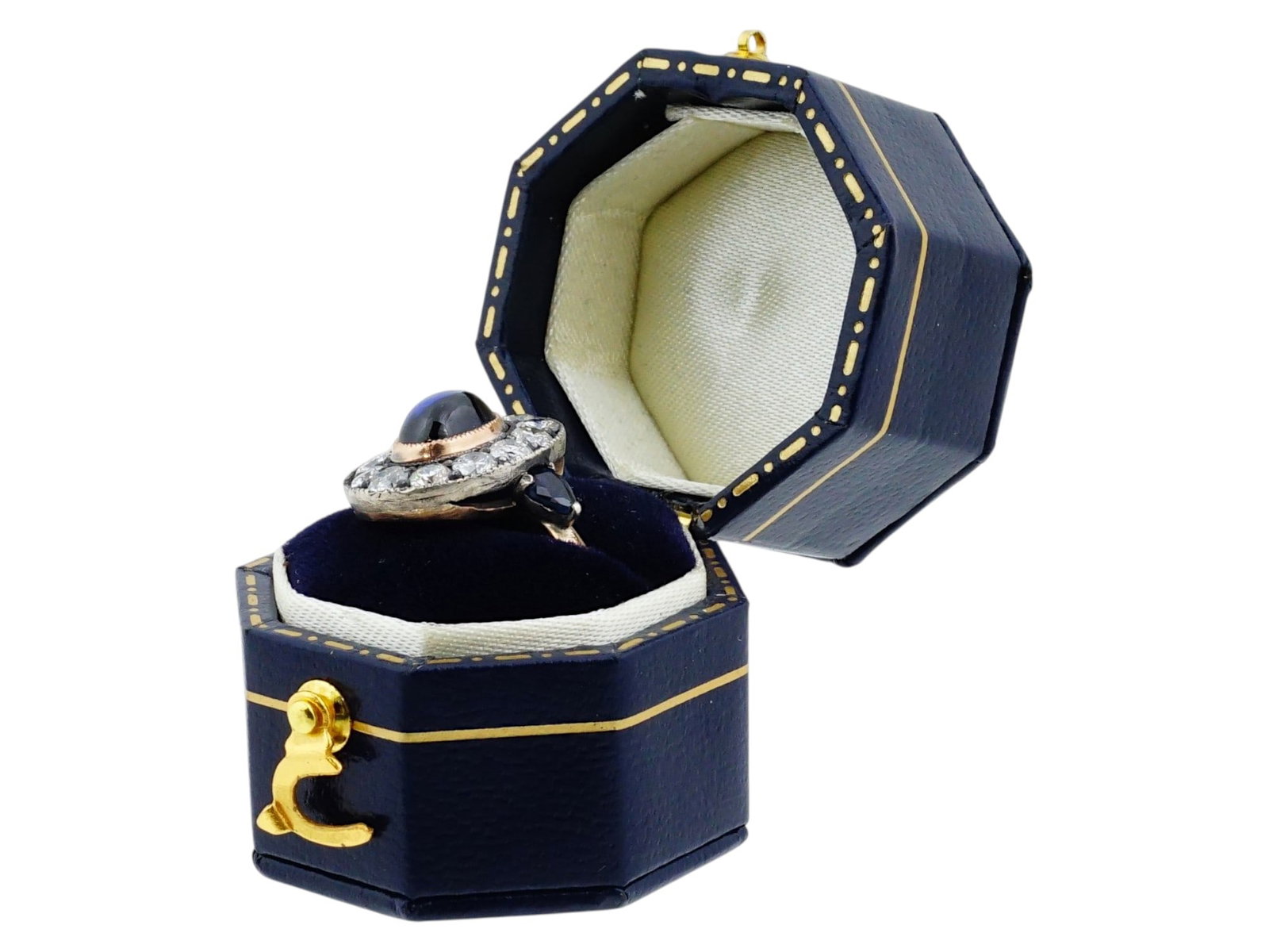 RUSSIAN 14K GOLD SILVER DIAMOND AND SAPPHIRE RING BOX: A Russian 14K Gold and silver ring. The ring features a central oval cabochon sapphire bezel set in gold, encircled by a halo of twelve old cut diamonds set in a silver topped gallery. The shoulders