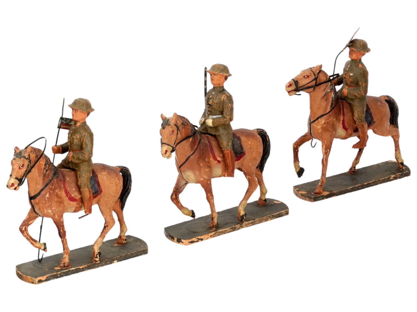 ANTIQUE SOLDIER HORSEBACK FIGURINES ON WOODEN BASES: A set of three antique soldier horseback figurines, crafted from composition material and meticulously hand-painted, stand as intricately detailed miniatures on charming wooden stands. The use of