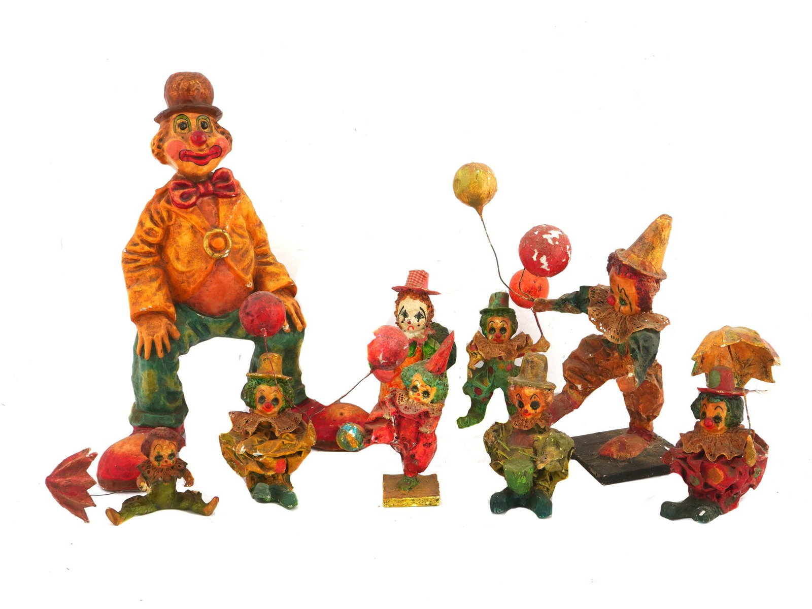 COLLECTION OF 8 PAPIER MACHE CLOWNS FIGURINES: A vintage collection of papier mache clowns figurines. Total of eight figures of varying sizes. All clowns are handcrafted and hand painted in bright colors and have accessories such as bow ties,