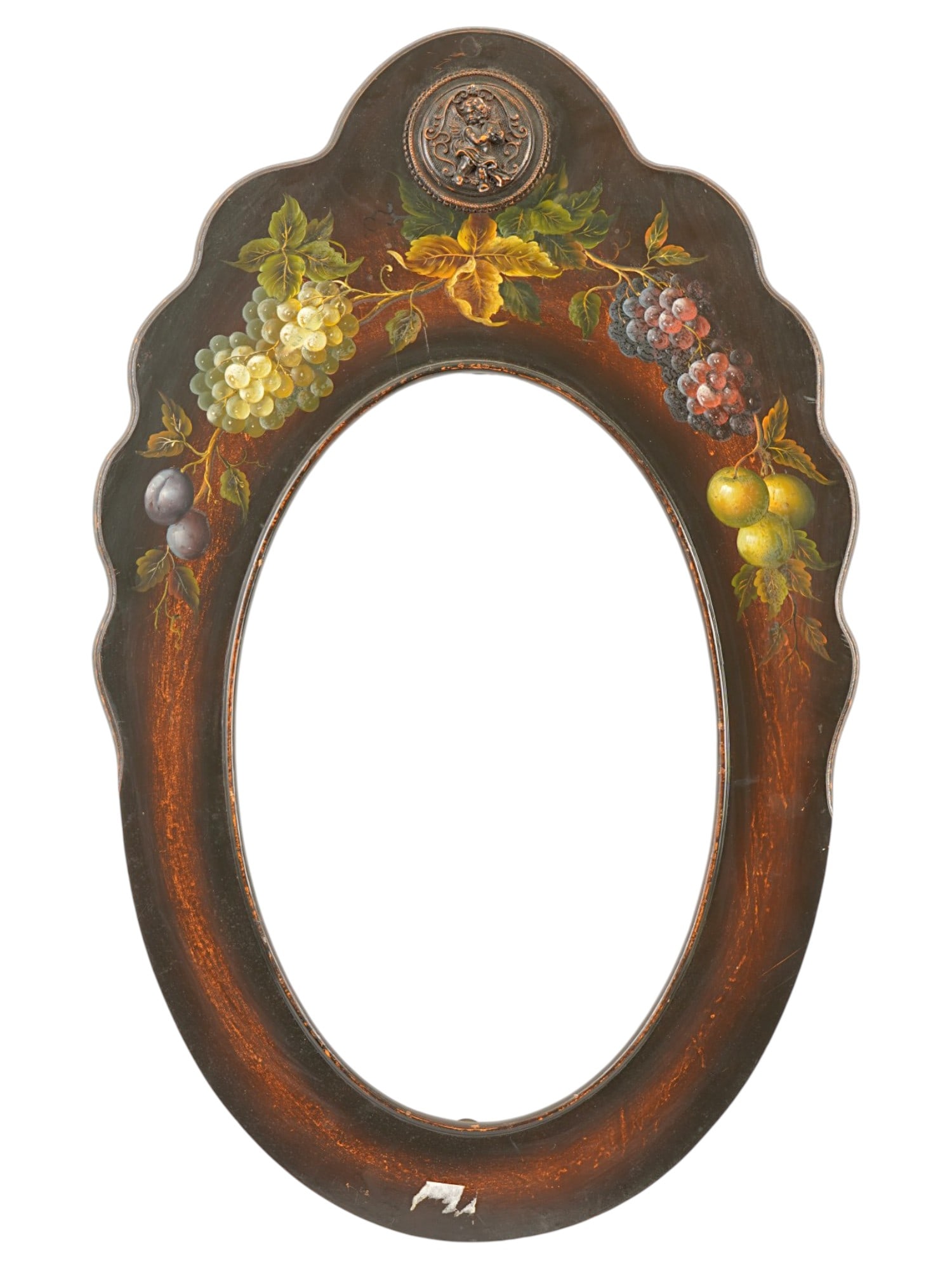 VINTAGE HAND PAINTED OVAL WOODEN FRAME: A vintage oval wooden frame features a scalloped cresting hand-painted with a vibrant still life of fruit, including grapes other fruits, set against a dark stained ground. The top center is accented 