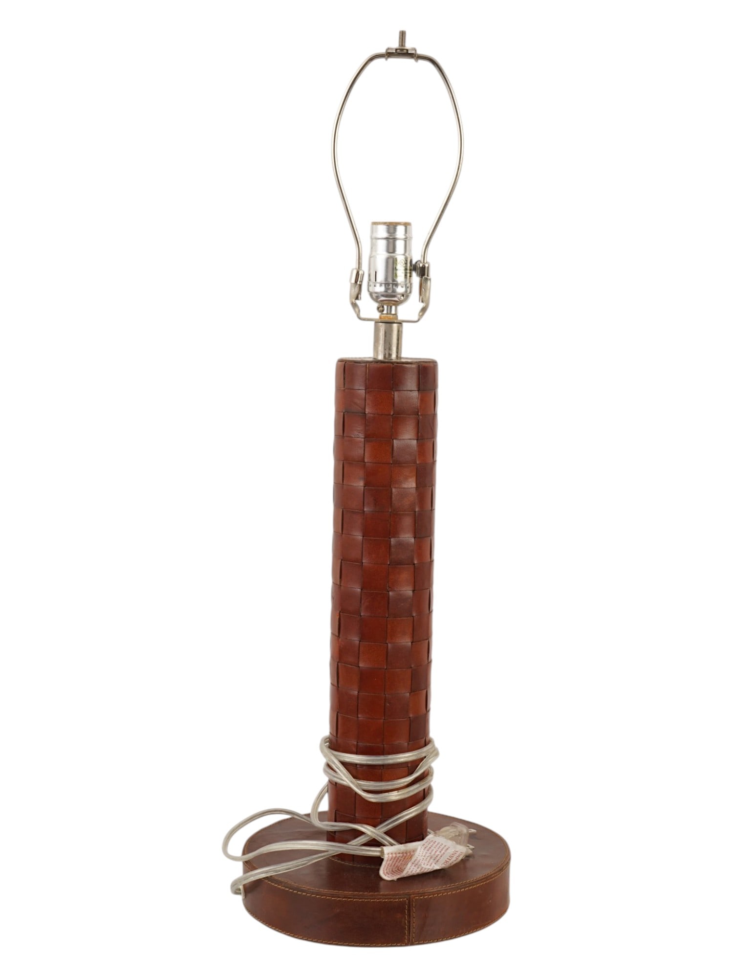VINTAGE FRENCH ART DECO WOVEN LEATHER TABLE LAMP: A vintage French Art Deco woven leather table lamp features a cylindrical column and tiered circular base entirely encased in brown leather with decorative stitching. The piece is fitted with