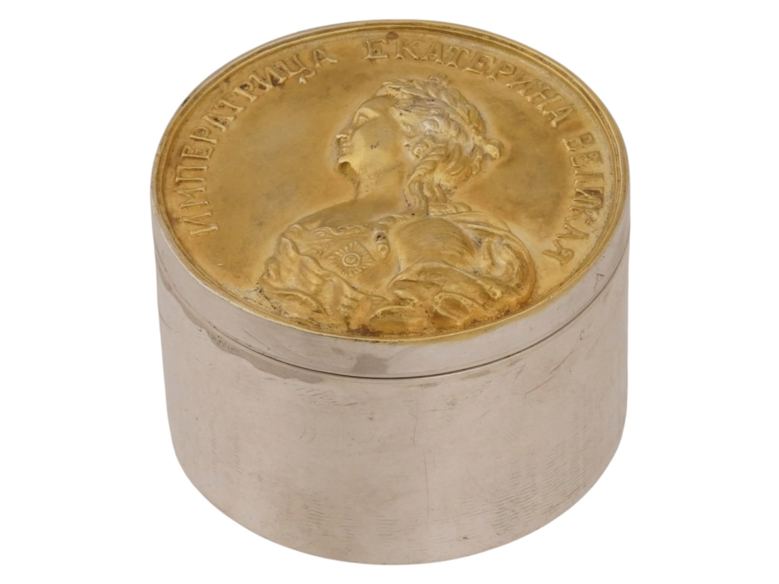 RUSSIAN SILVER ROUND BOX W EMPRESS CATHERINE THE GREAT: A Russian silver round box features a lift-off lid inset with a commemorative medal of Empress Catherine The Great. The medal depicts the profile of the Empress in relief with a Cyrillic inscription.