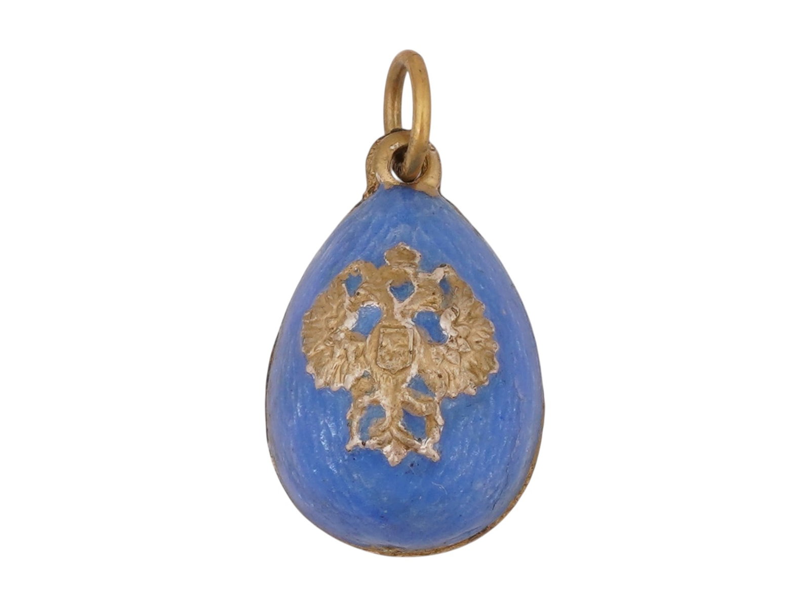 RUSSIAN SILVER GUILLOCHE ENAMEL EASTER EGG PENDANT: A Russian 88 gilt Silver and enamel Easter egg pendant. The pendant is covered with a Guilloche enamel in a blue shade, and adorned with a gilt Silver relief design depicting an Imperial double